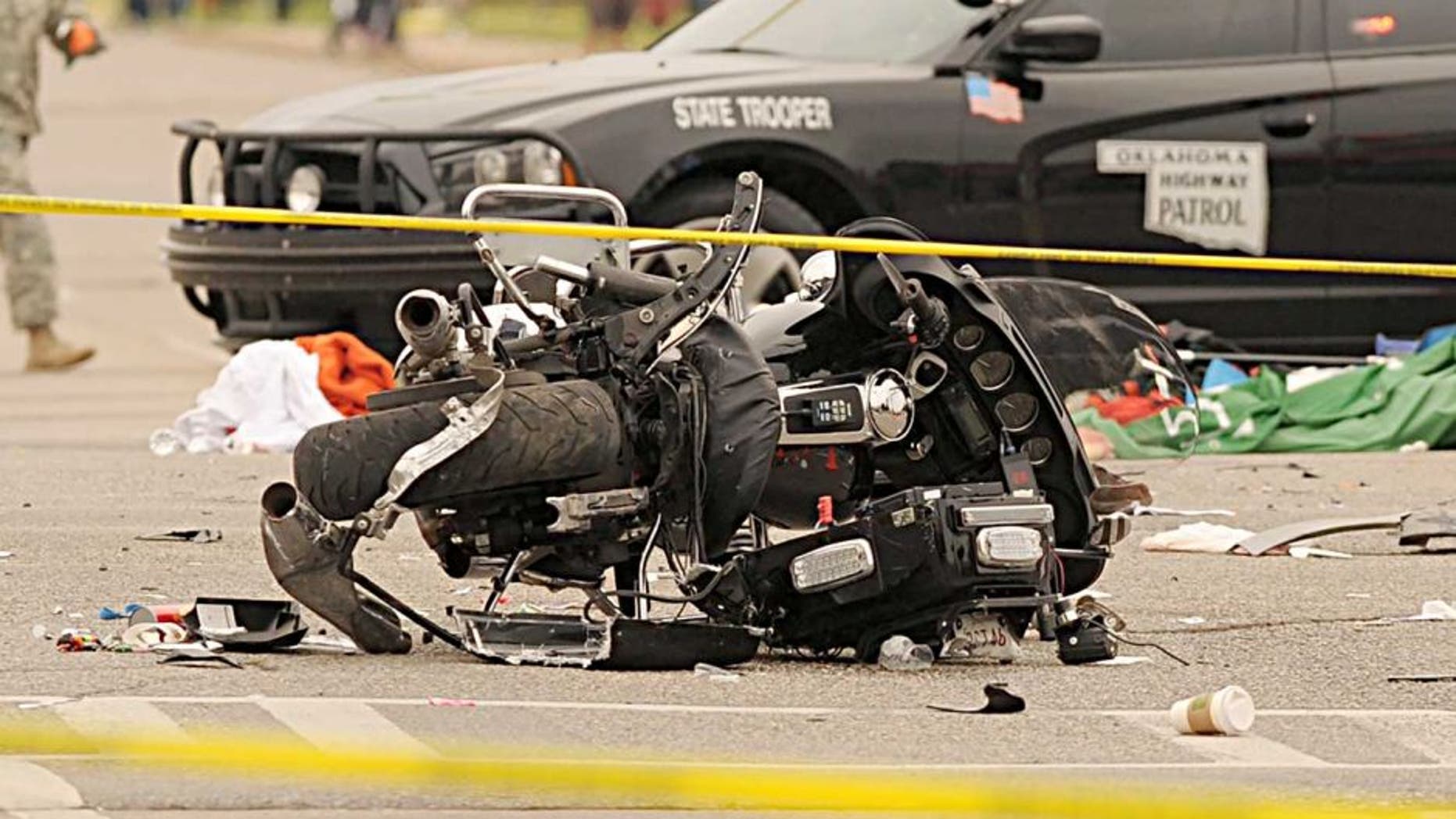 A damaged police motorcycle rests in the intersection after a vehicle crashed into a crowd of spectators during the Oklahoma State University homecoming parade, causing multiple injuries, on Saturday, Oct. 24, 2015 in Stillwater, Oka.(AP Photo/Brody Schmidt)