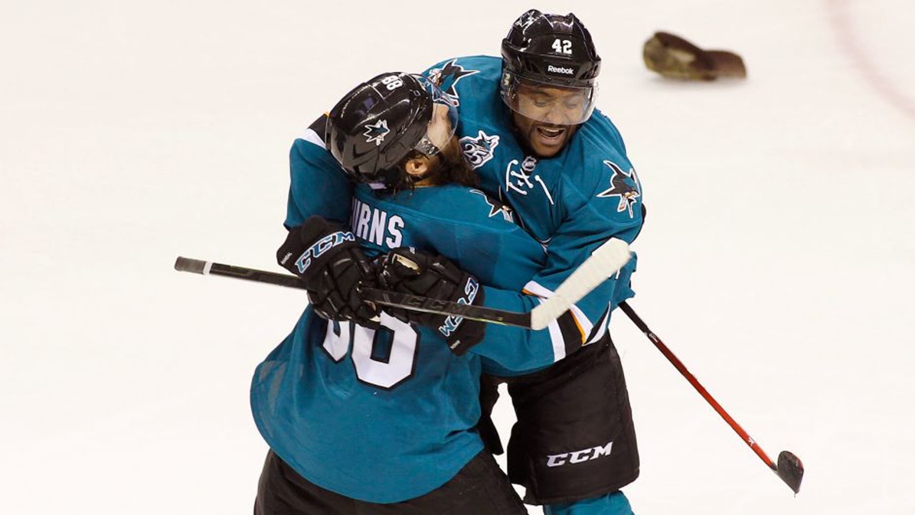 San Jose Sharks' Joel Ward, right, celebrates with teammate Brent Burns after scoring his third goal of the game for a hat trick against the Carolina Hurricanes during the third period of an NHL hockey game, Saturday, Oct. 24, 2015, in San Jose, Calif. (AP Photo/George Nikitin)