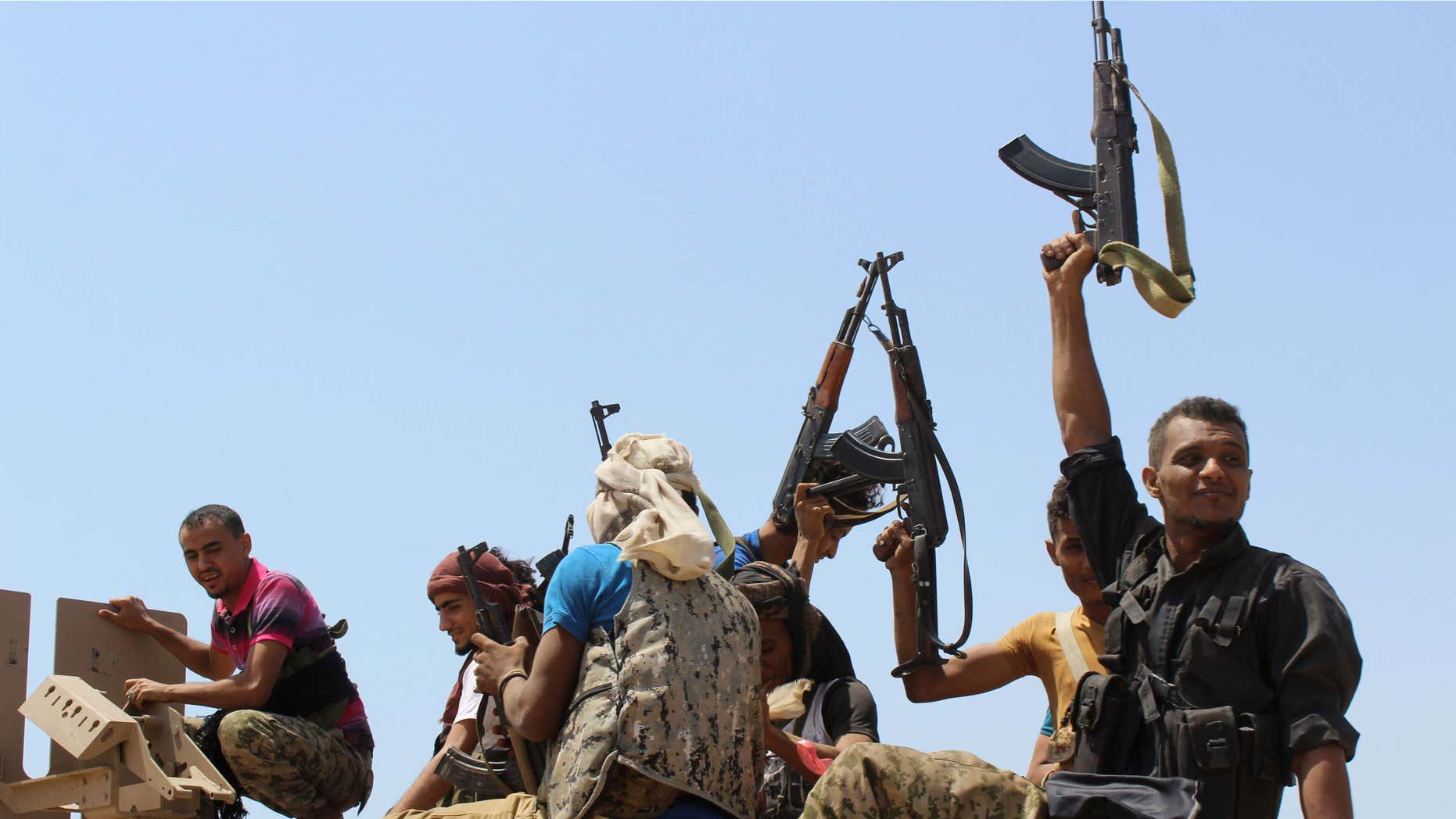 Oct. 2, 2015: Fighters against Shiite rebels known as Houthis hold up their weapons as they ride on an armored vehicle near the strait of Bab al-Mandab, west of the southern port city of Aden, to take back the control of the strait, Yemen.