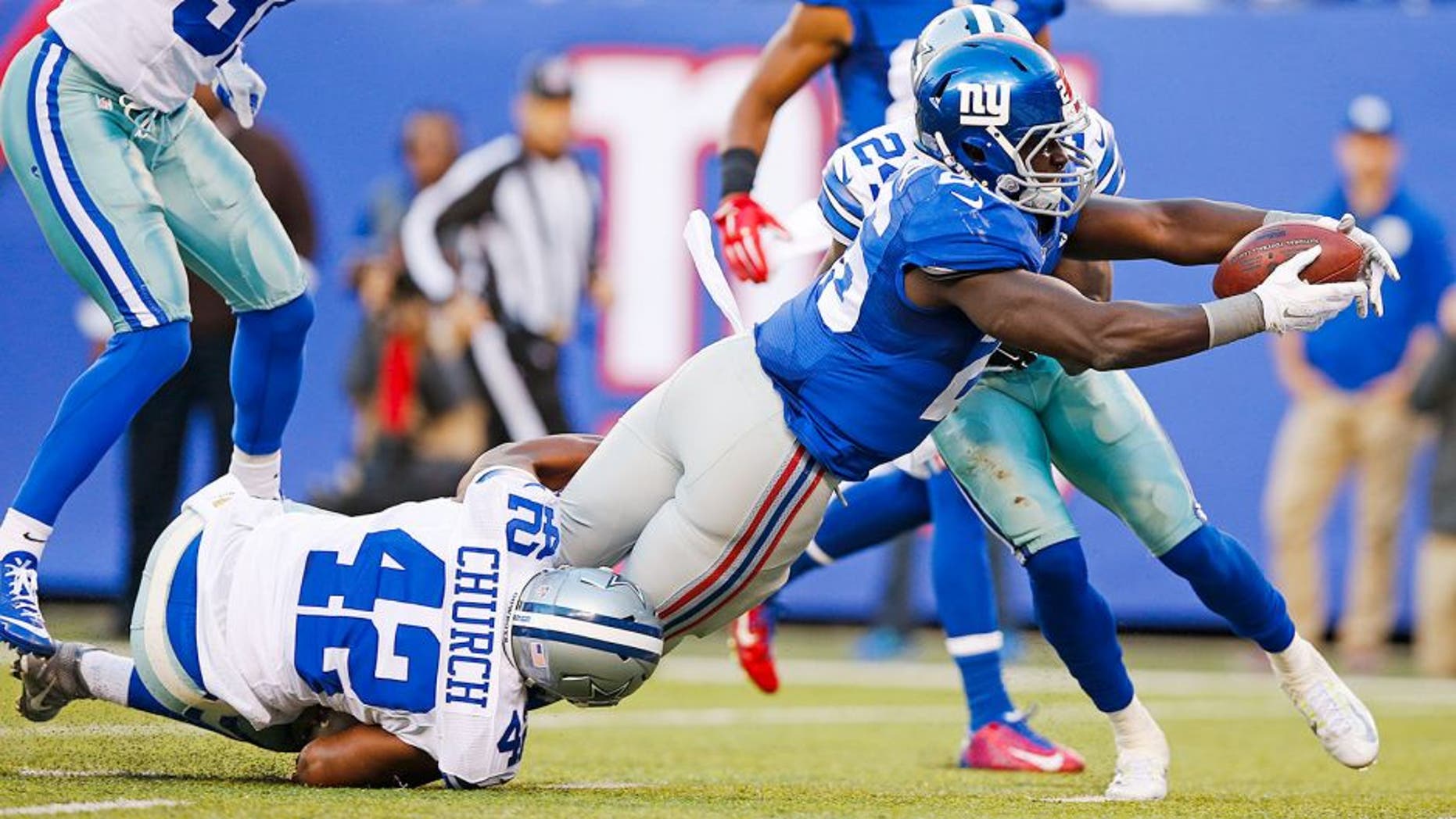 New York Giants running back Orleans Darkwa (26) dives past Dallas Cowboys' Barry Church (42) for a touchdown as Byron Jones (31) chases them during the first half of an NFL football game, Sunday, Oct. 25, 2015, in East Rutherford, N.J. (AP Photo/Kathy Willens)