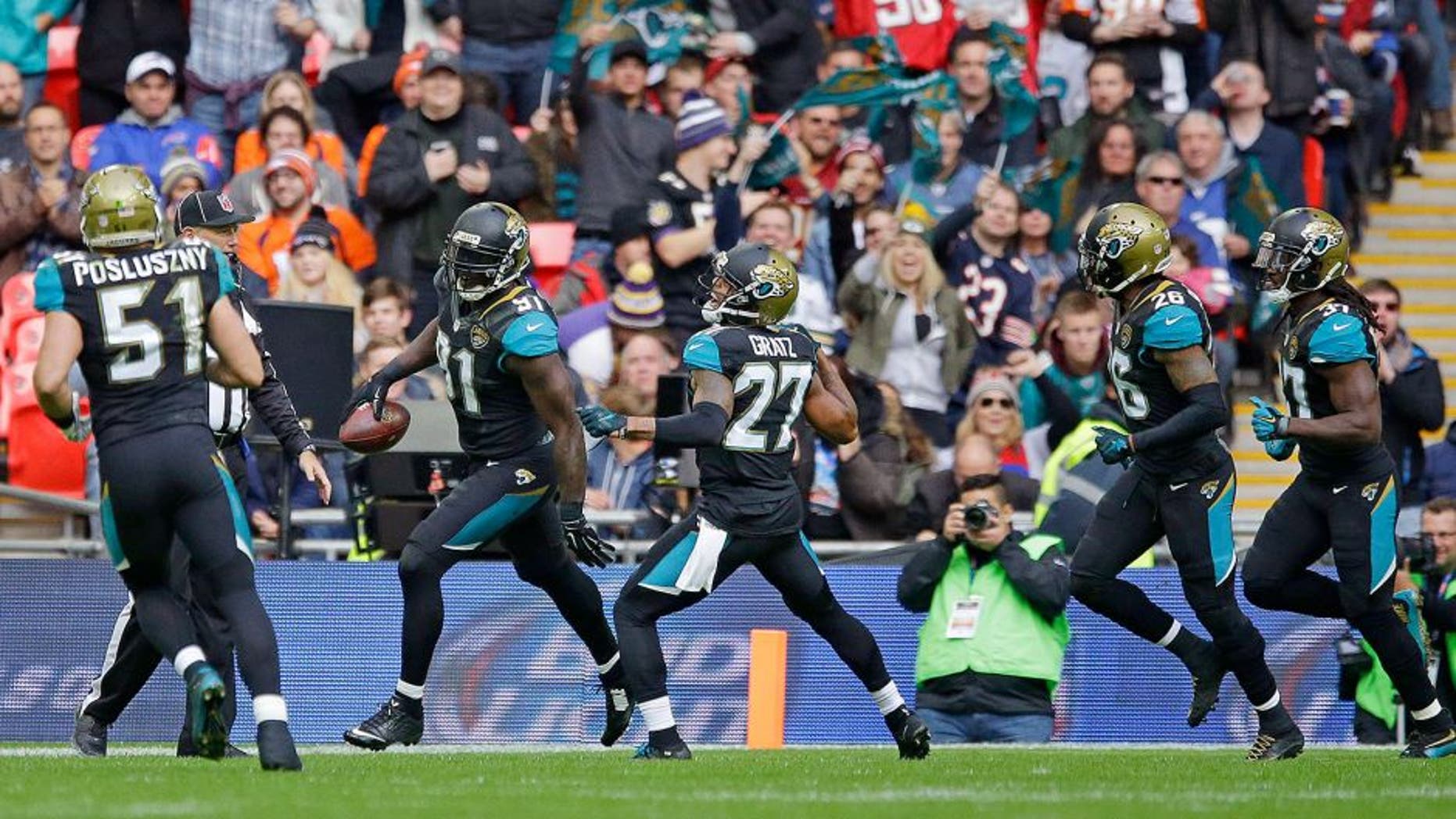Jacksonville Jaguars defensive end Chris Clemons (91), second left reacts after scoring a touchdown during the NFL game between Buffalo Bills and Jacksonville Jaguars at Wembley Stadium in London, Sunday, Oct. 25, 2015. (AP Photo/Matt Dunham)
