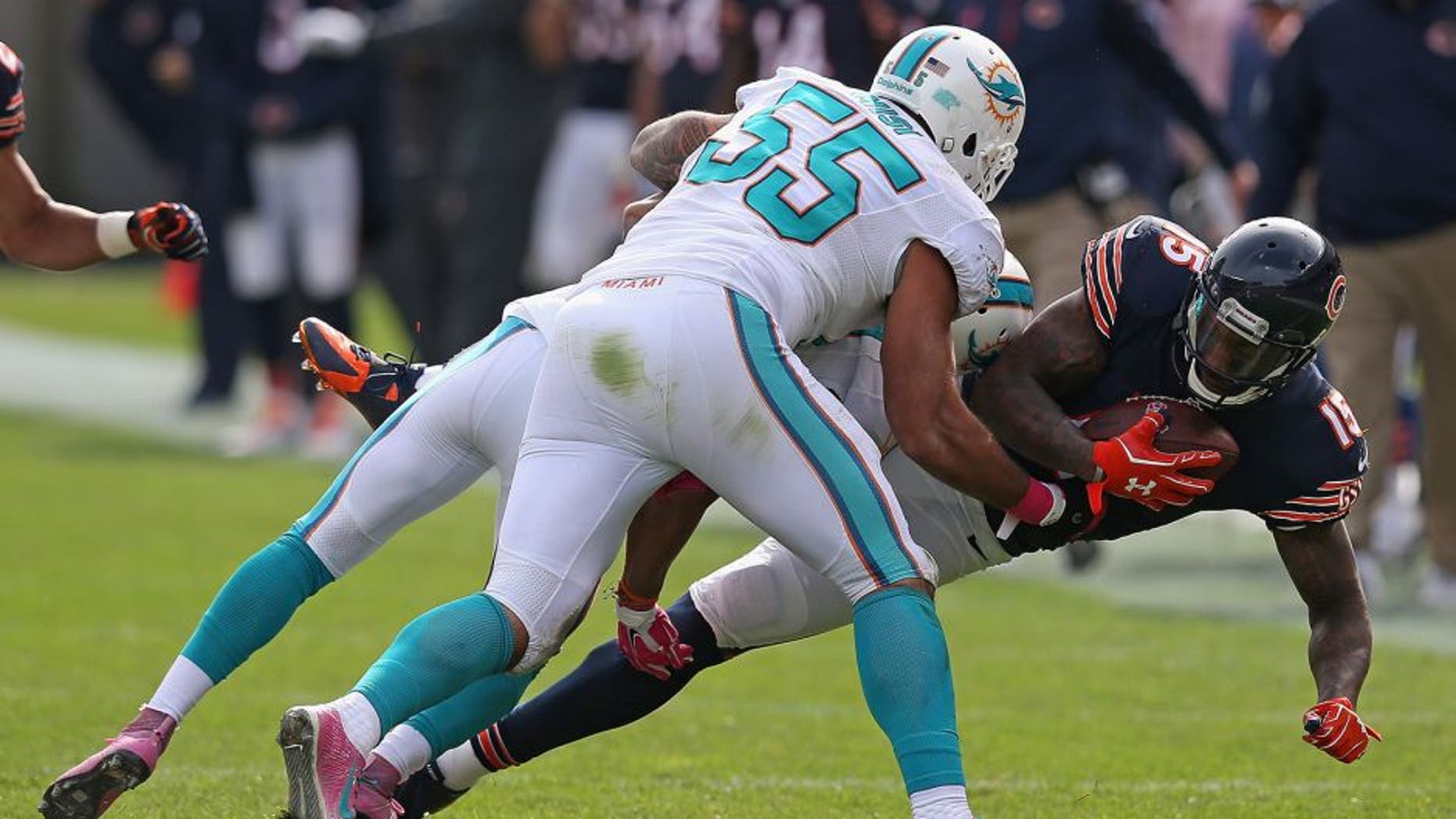 CHICAGO, IL - OCTOBER 19: Brandon Marshall #15 of the Chicago Bears is tackled by Cortland Finnegan #24 and Koa Misi #55 of the Miami Dolphins during the third quarter at Soldier Field on October 19, 2014 in Chicago, Illinois. (Photo by Jonathan Daniel/Getty Images)