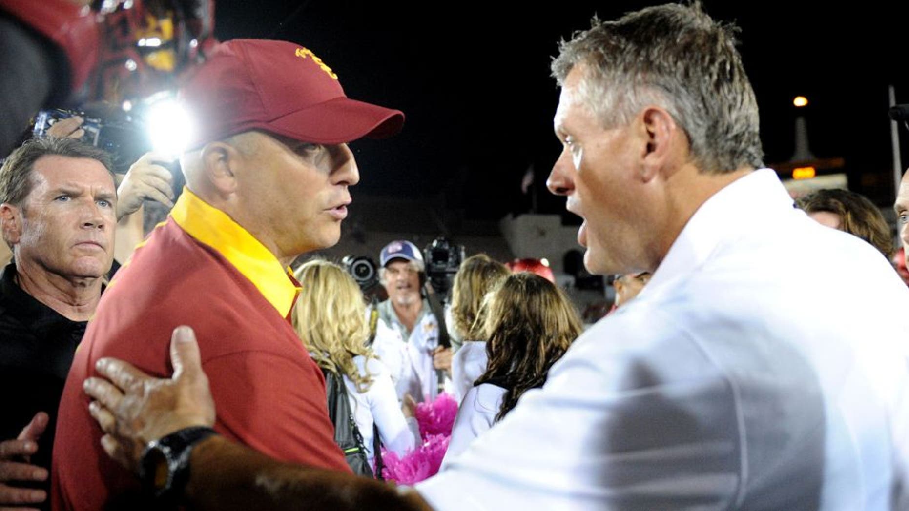 October 24, 2015; Los Angeles, CA, USA; Southern California Trojans interim head coach Clay Helton meets with Utah Utes head coach Kyle Whittingham following the 42-24 victory at Los Angeles Memorial Coliseum. Mandatory Credit: Gary A. Vasquez-USA TODAY Sports