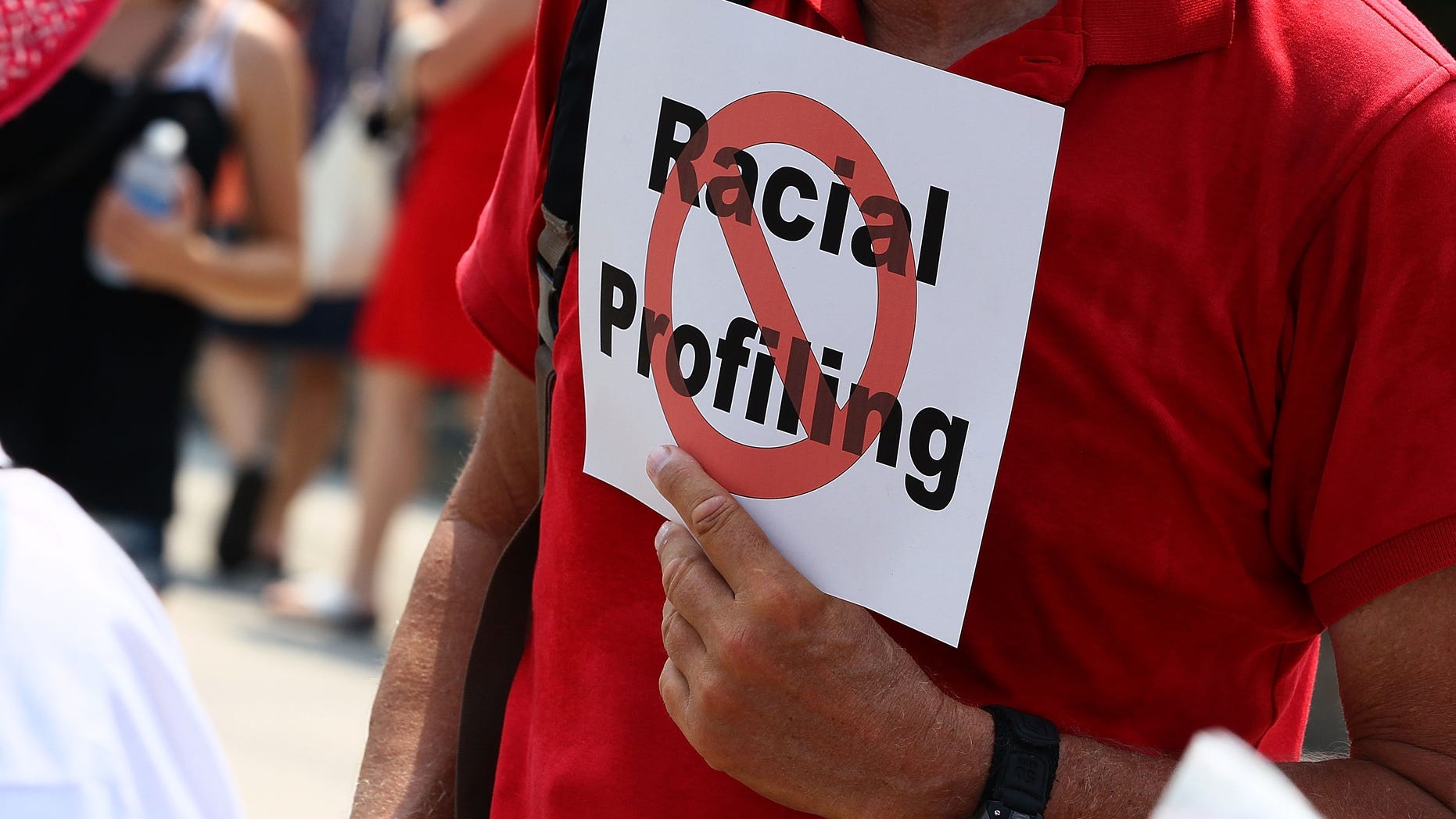WASHINGTON - JULY 07: A man holds a sign against racial profiling during a protest with Community and faith leaders from Arizona in front of the White House on July 7, 2010 in Washington, DC. Activists plan a 24-hour vigil outside the White House to protest the imminent new immigration law in Arizona. (Photo by Mark Wilson/Getty Images)