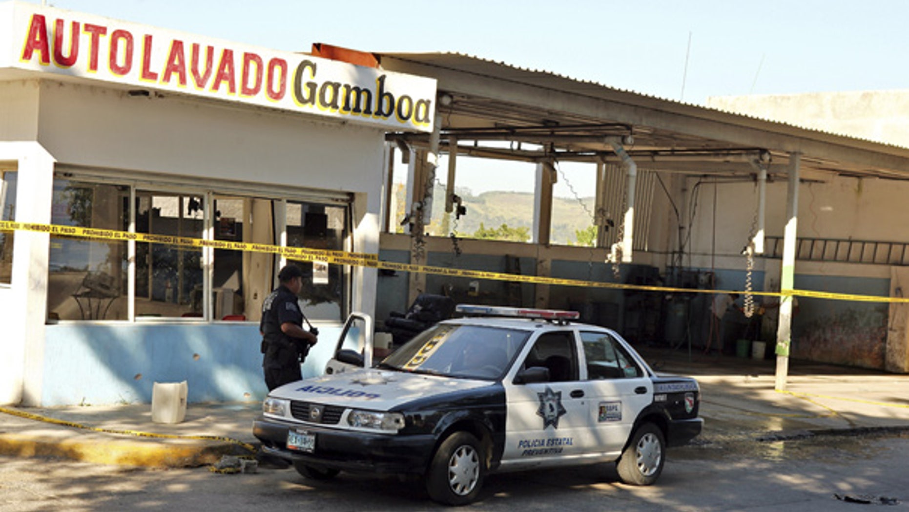 Oct. 27: A police officer is seen outside a car wash after gunmen burst into the shop and killed at least 15 people in Tepic, Mexico.