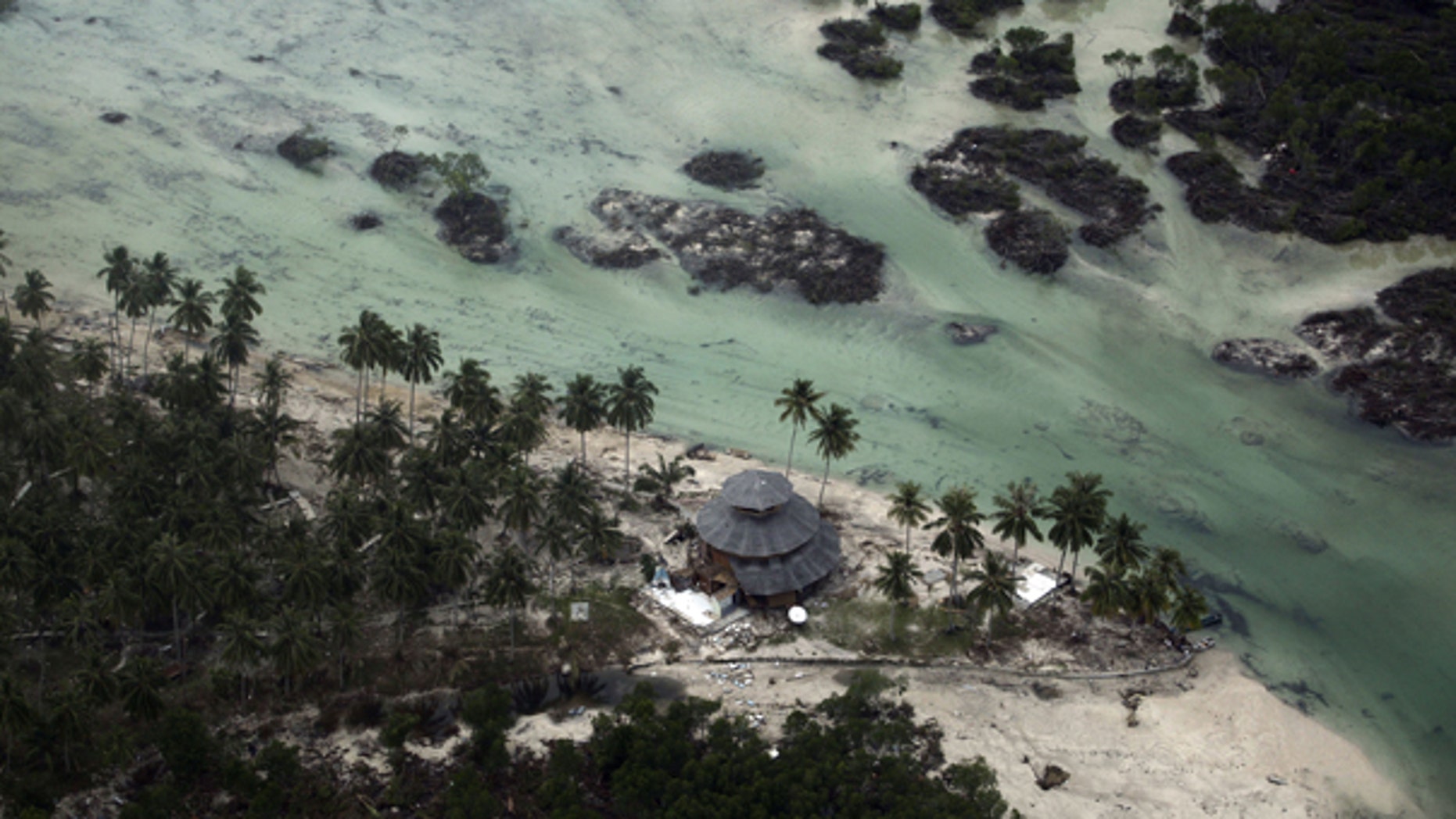 Oct. 27: This aerial photo shows a damaged building in a village flattened by Monday's earthquake triggered tsunami on Pagai island, West Sumatra, Indonesia.