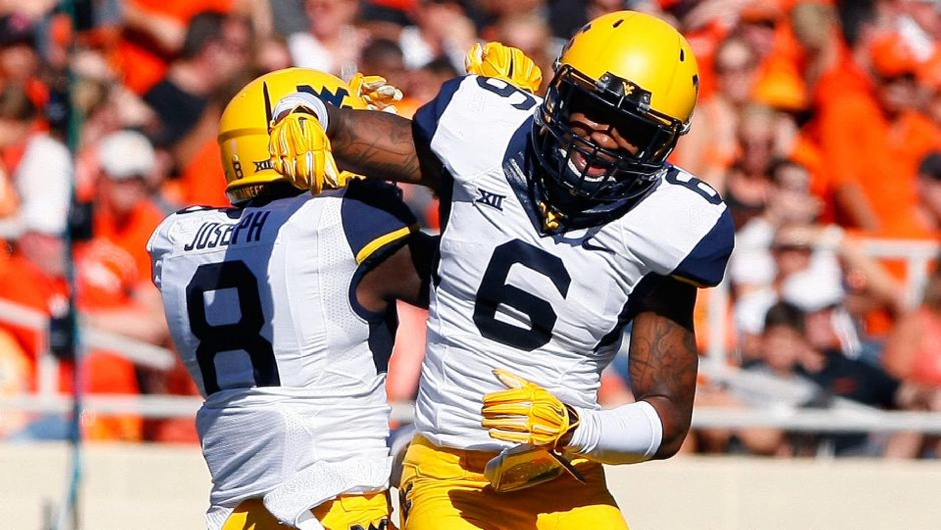 Oct 25, 2014; Stillwater, OK, USA; West Virginia Mountaineers safety Dravon Henry (6) and safety Karl Joseph (8) celebrate after Dravon Henry intercepted an Oklahoma State Cowboy pass during the first quarter at Boone Pickens Stadium. Mandatory Credit: Alonzo Adams-USA TODAY Sports