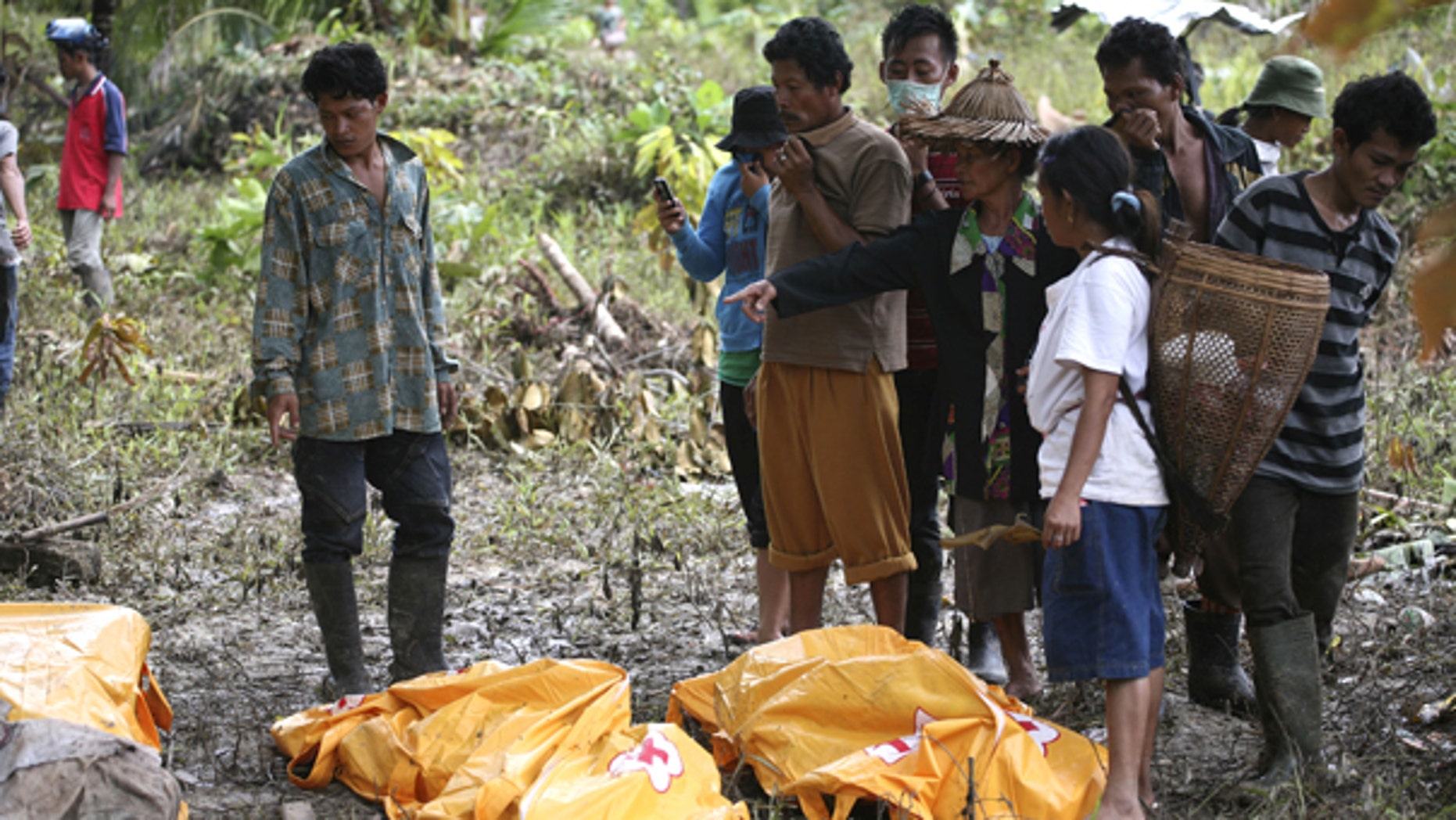 Oct. 29: Survivors look at the body of their family member who died in a tsunami at Munte, Indonesia. he toll from Monday's tsunami rose to more than 400 on Friday as officials found more bodies, and about 300 people were still missing, according to a provincial disaster management center official.