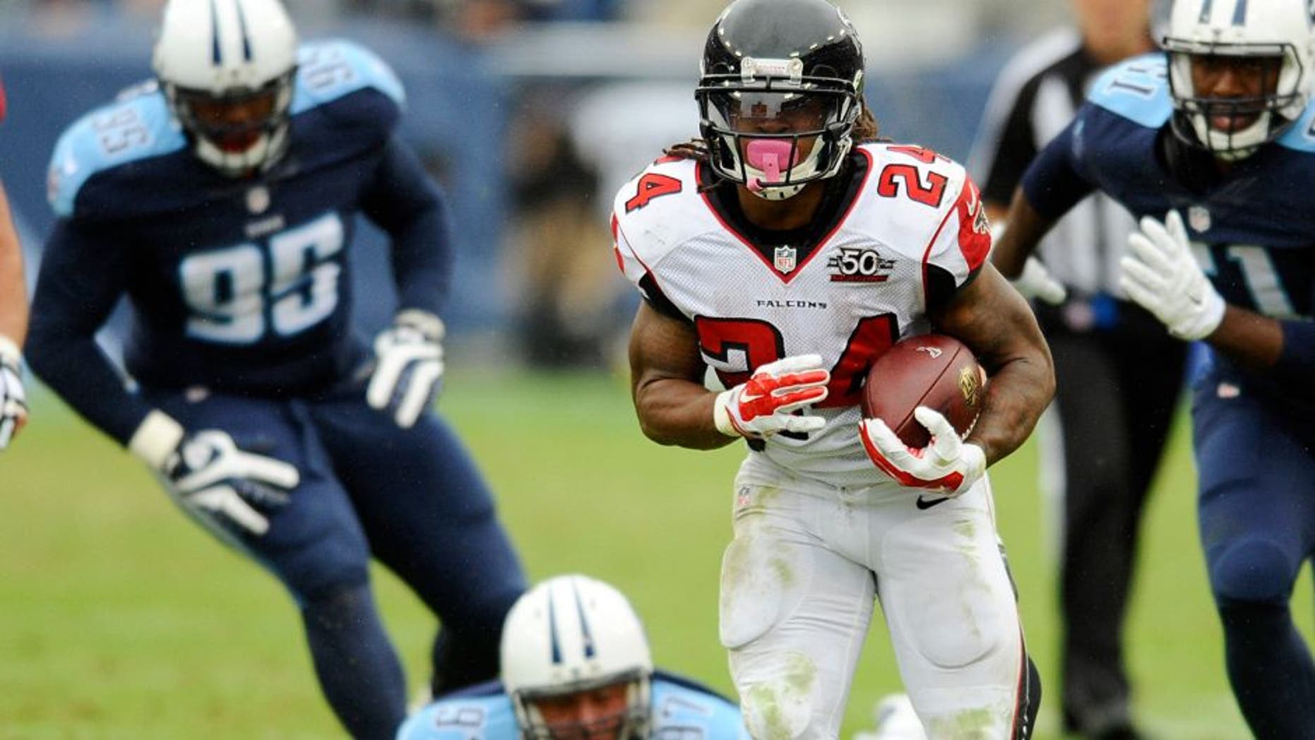 Oct 25, 2015; Nashville, TN, USA; Atlanta Falcons running back Devonta Freeman (24) runs for a first down during the second half against the Tennessee Titans at Nissan Stadium. The Falcons won 10-7. Mandatory Credit: Christopher Hanewinckel-USA TODAY Sports