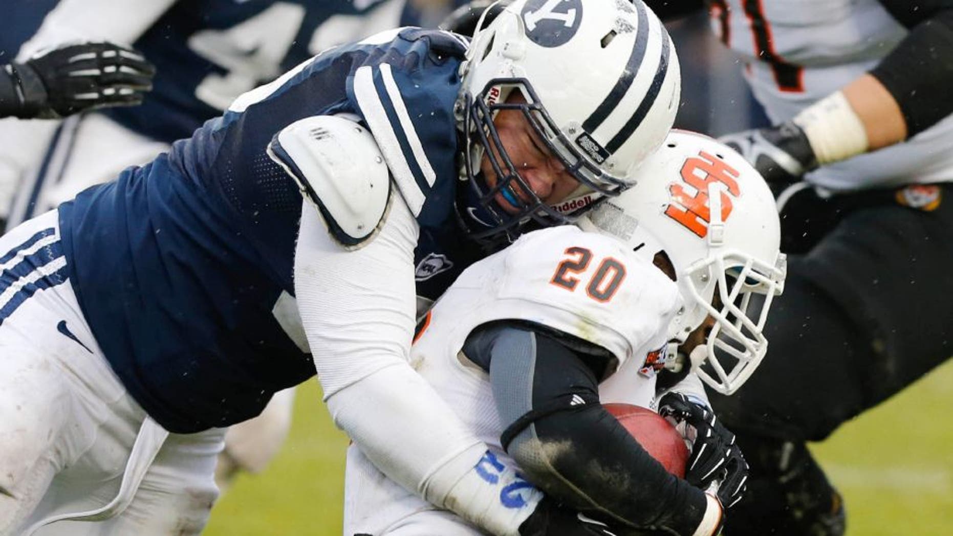 Nov 16, 2013; Provo, UT, USA; Idaho State Bengals running back Aaron Prier (20) is tackled by Brigham Young Cougars defensive lineman Logan Taele (95) during the third quarter at Lavell Edwards Stadium. BYU won 59-13. Mandatory Credit: Chris Nicoll-USA TODAY Sports.