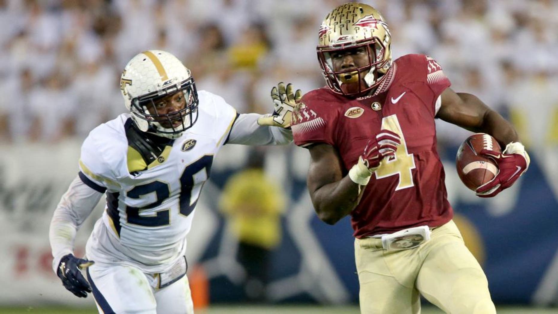Oct 24, 2015; Atlanta, GA, USA; Florida State Seminoles running back Dalvin Cook (4) runs against Georgia Tech Yellow Jackets defensive back Lawrence Austin (20) in the second quarter of their game at Bobby Dodd Stadium. Mandatory Credit: Jason Getz-USA TODAY Sports