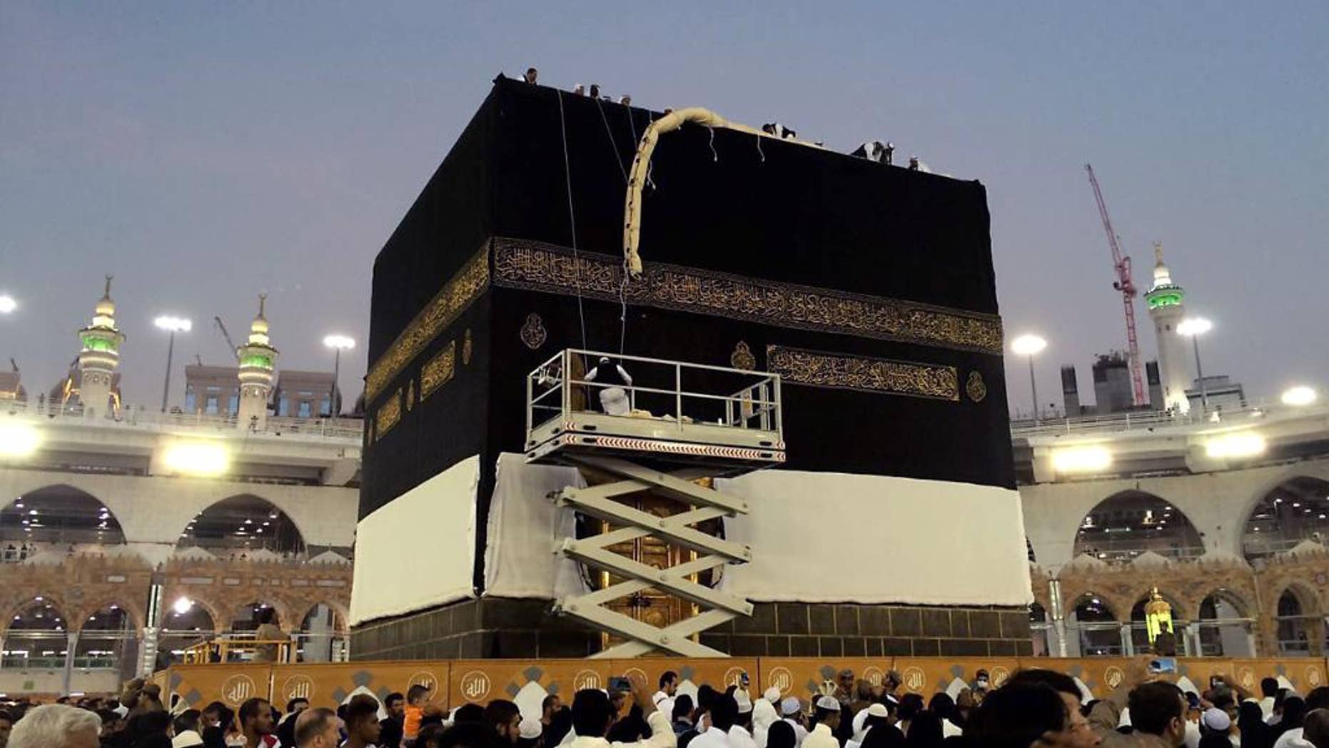 Saudi workers change the Kiswah (the cloth that covers the Kaaba) in Mecca, Saudi Arabia, Sunday, Sept. 11, 2016. Workers change the Kiswah once a year when pilgrims leave for the plains of Mount Arafat during the Hajj. (AP Photo/ Hussein Malla)