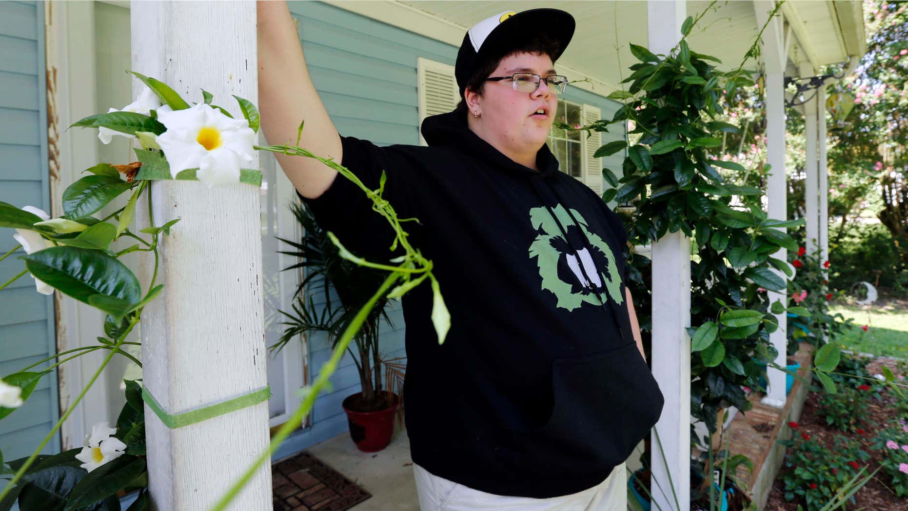 FILE - In this Aug. 25, 2015 file photo, Gavin Grimm leans on a post on his front porch during an interview at his home in Gloucester, Va.