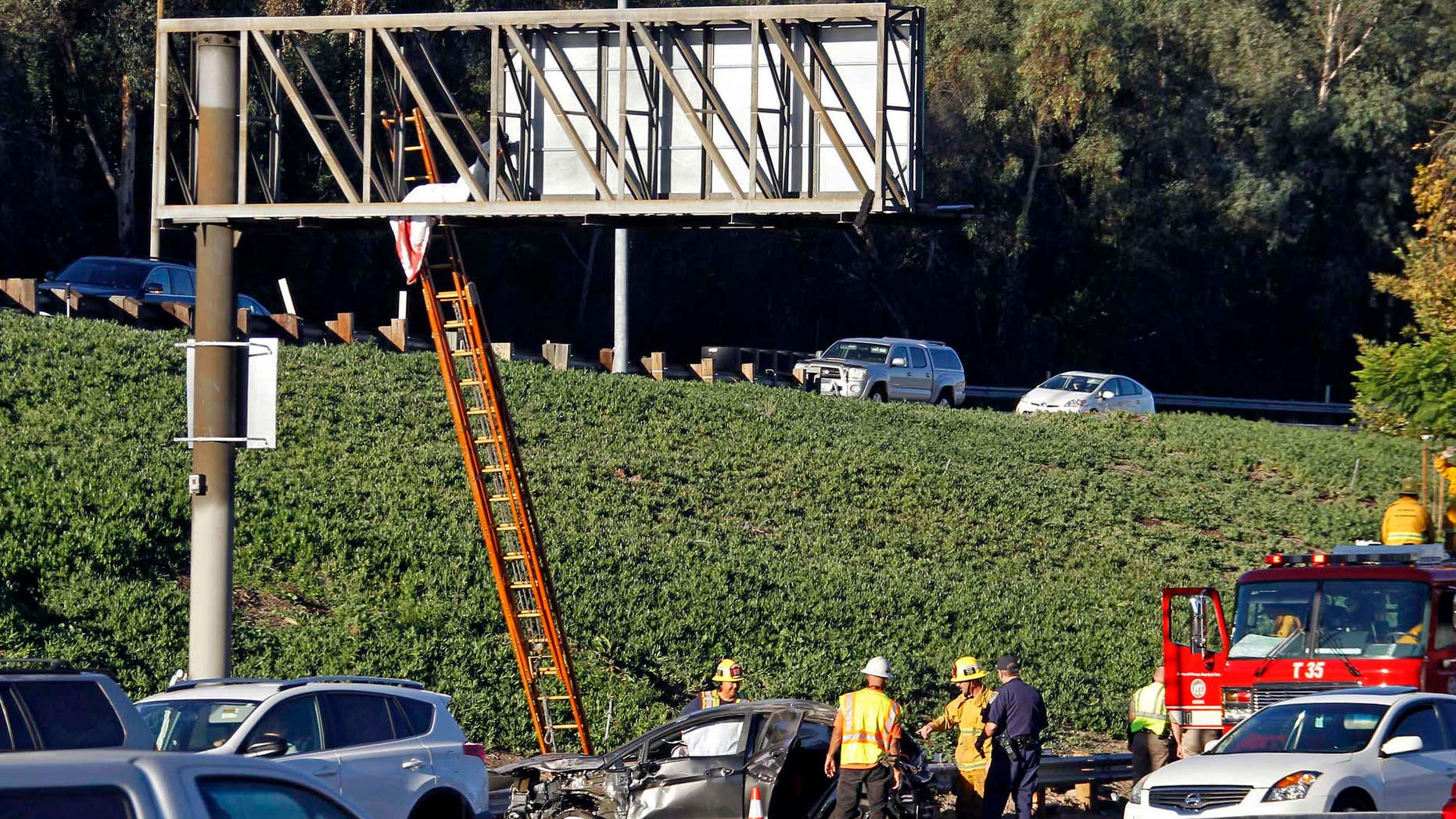 Oct. 30, 2015: he body of a driver ejected when his car rolled over several times on southbound Interstate 5 is seen where it landed on an overhead freeway sign north of downtown Los Angeles.