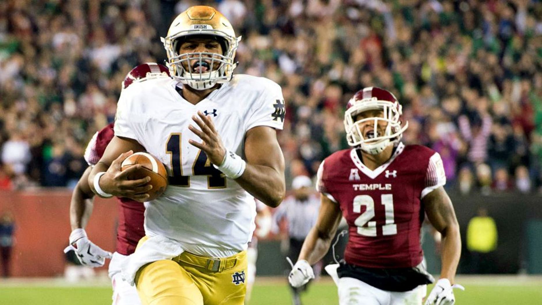Oct 31, 2015; Philadelphia, PA, USA; Notre Dame Fighting Irish quarterback DeShone Kizer (14) runs for a touchdown as Temple Owls safety Alex Wells (21) pursues in the second quarter at Lincoln Financial Field. Mandatory Credit: Matt Cashore-USA TODAY Sports