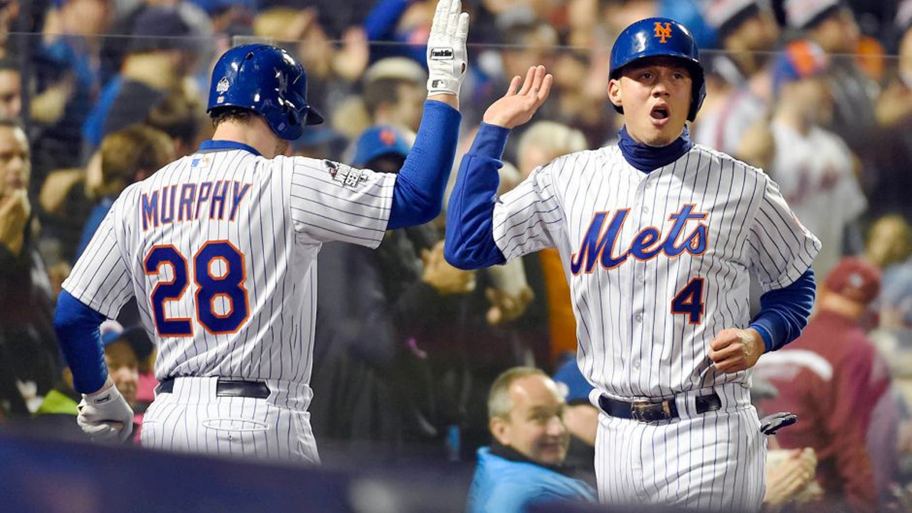 Oct 31, 2015; New York City, NY, USA; New York Mets shortstop Wilmer Flores (4) celebrates with second baseman Daniel Murphy (28) after scoring a run against the Kansas City Royals in the third inning in game four of the World Series at Citi Field. Mandatory Credit: Robert Deutsch-USA TODAY Sports