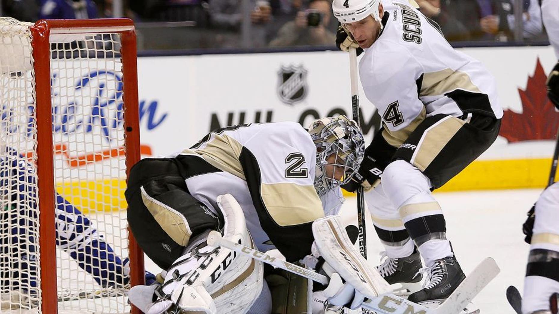 Oct 31, 2015; Toronto, Ontario, CAN; Pittsburgh Penguins defenseman Rob Scuderi (4) helps Pittsburgh Penguins goaltender Marc-Andre Fleury (29) cover a loose puck against the Toronto Maple Leafs during the second period at the Air Canada Centre. Mandatory Credit: John E. Sokolowski-USA TODAY Sports