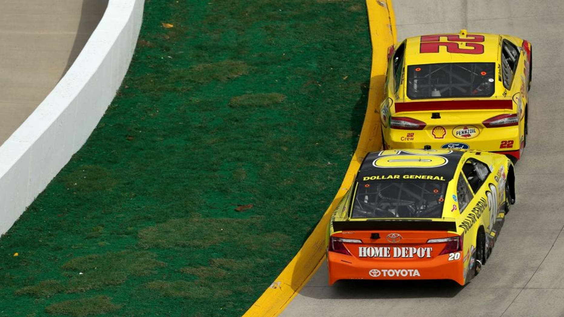 Joey Logano, driver of the #22 Shell-Pennzoil Ford, races with Matt Kenseth, driver of the #20 Dollar General Toyota, during the NASCAR Sprint Cup Series STP 500 at Martinsville Speedway on March 30, 2014 in Martinsville, Virginia.