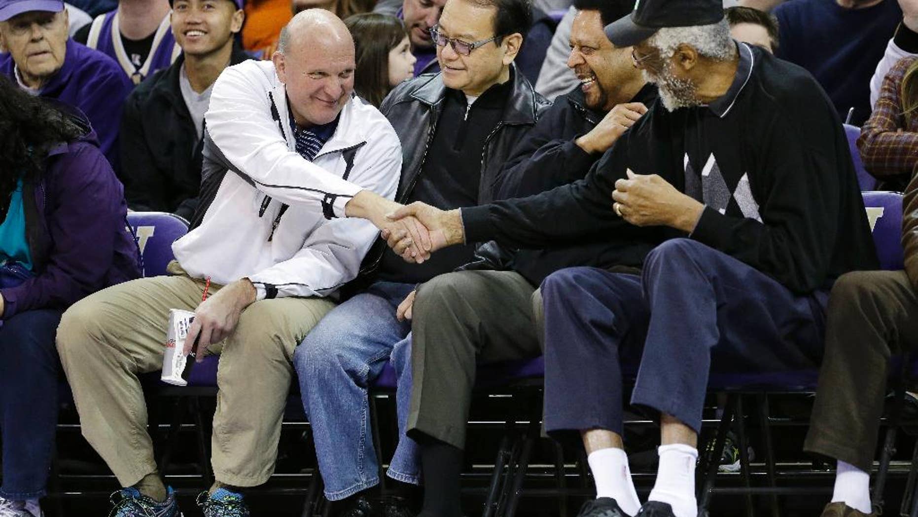 FILE - In this Jan. 25, 2014, photo, then-Microsoft CEO Steve Ballmer, left, shakes hands with former NBA players Bill Russell, right, and "Downtown" Freddie Brown as Omar Lee looks on during an NCAA college basketball game between Washington and Oregon State in Seattle. An individual with knowledge of negotiations to sell the Los Angeles Clippers said Shelly Sterling has reached an agreement to sell the team to Ballmer for $2 billion. The individual, who wasn’t authorized to speak publicly, told The Associated Press on Thursday, May 29, 2014, that Ballmer and the Sterling Family Trust now have a binding agreement. The deal now must be presented to the NBA. (AP Photo/Elaine Thompson, File)