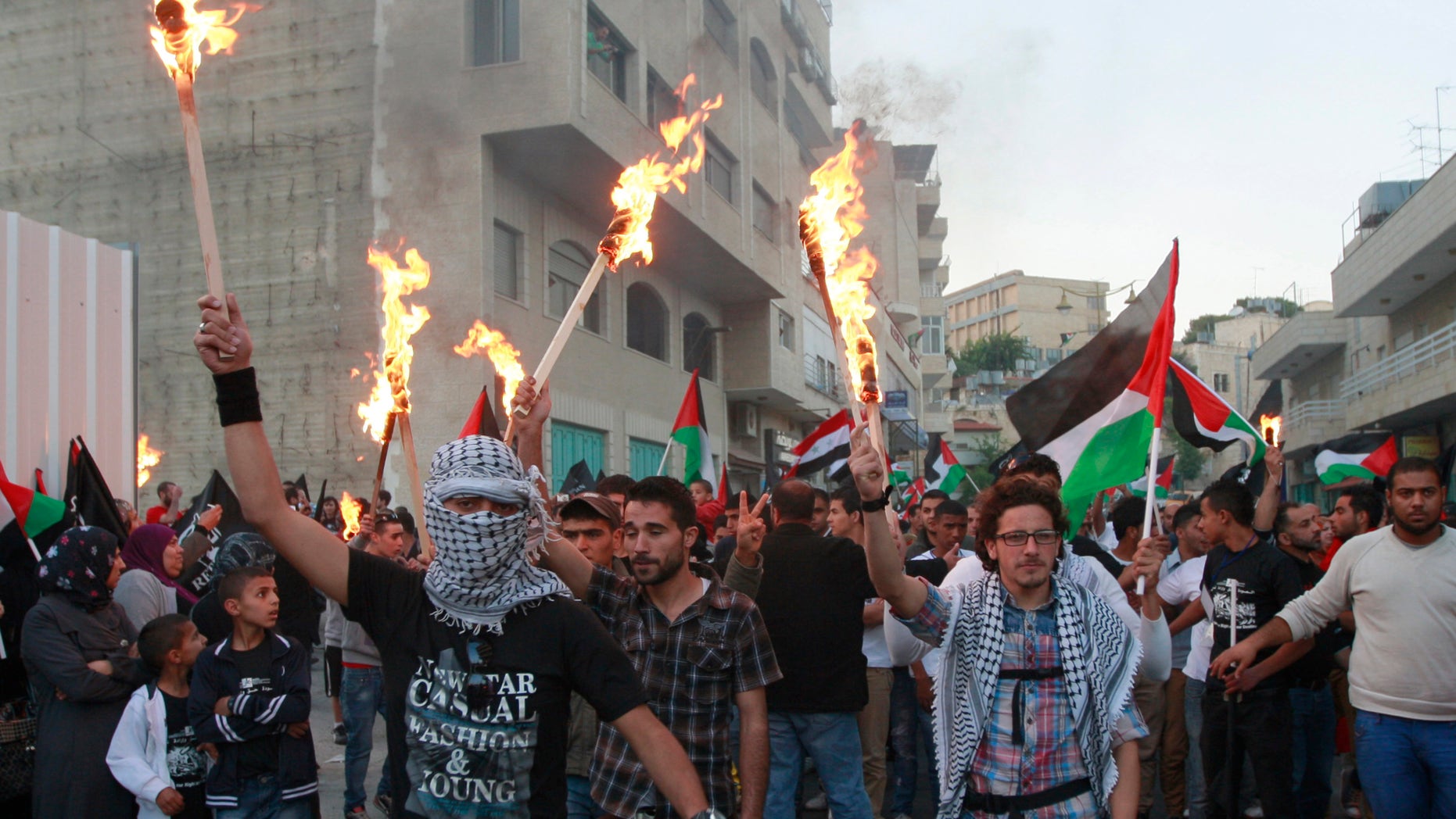 People hold torches as Palestinians hold a rally to commemorate the 1948 creation of the Israeli state, known in Arabic as "Nakba Day," or "Day of the Catastrophe" in the West Bank town of Bethlehem, Tuesday, May 14, 2013. (AP Photo/Majdi Mohammed)