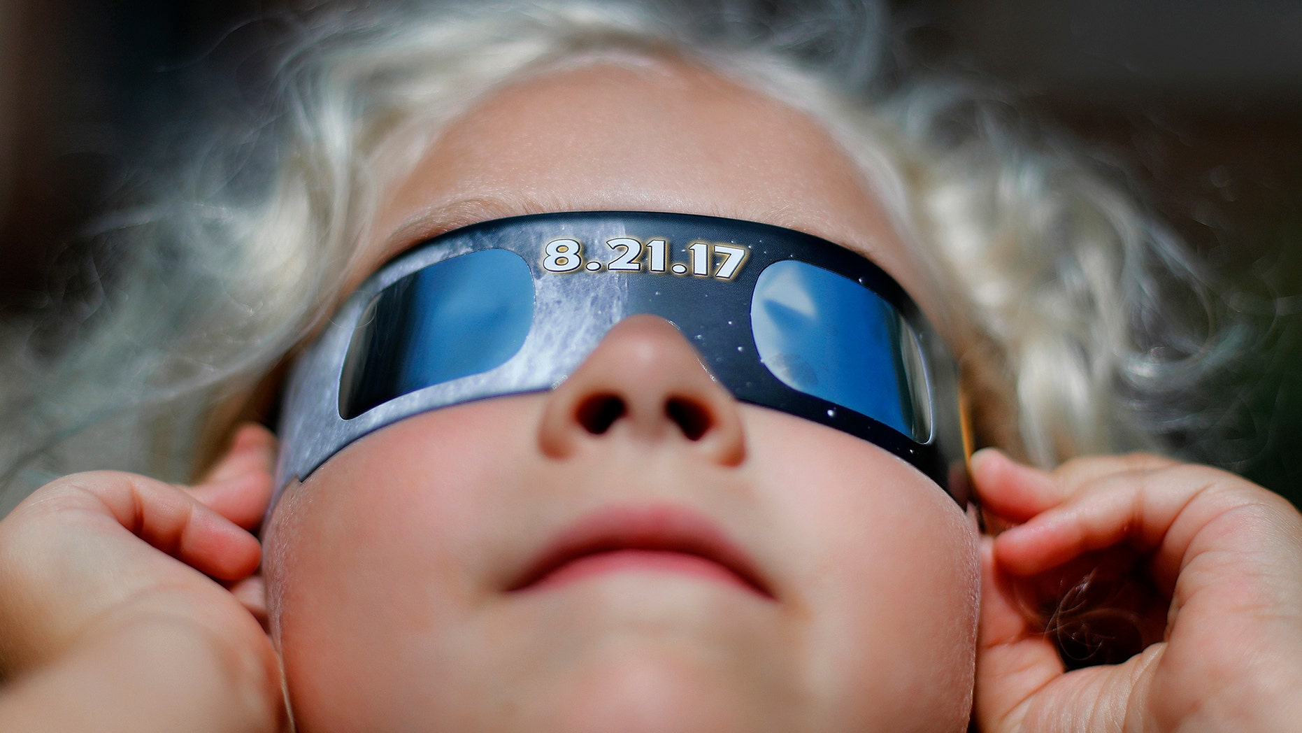 File photo: Piper Truza watches a phase of a partial solar eclipse visible in Detroit, Monday, Aug. 21, 2017. (AP Photo/Paul Sancya)