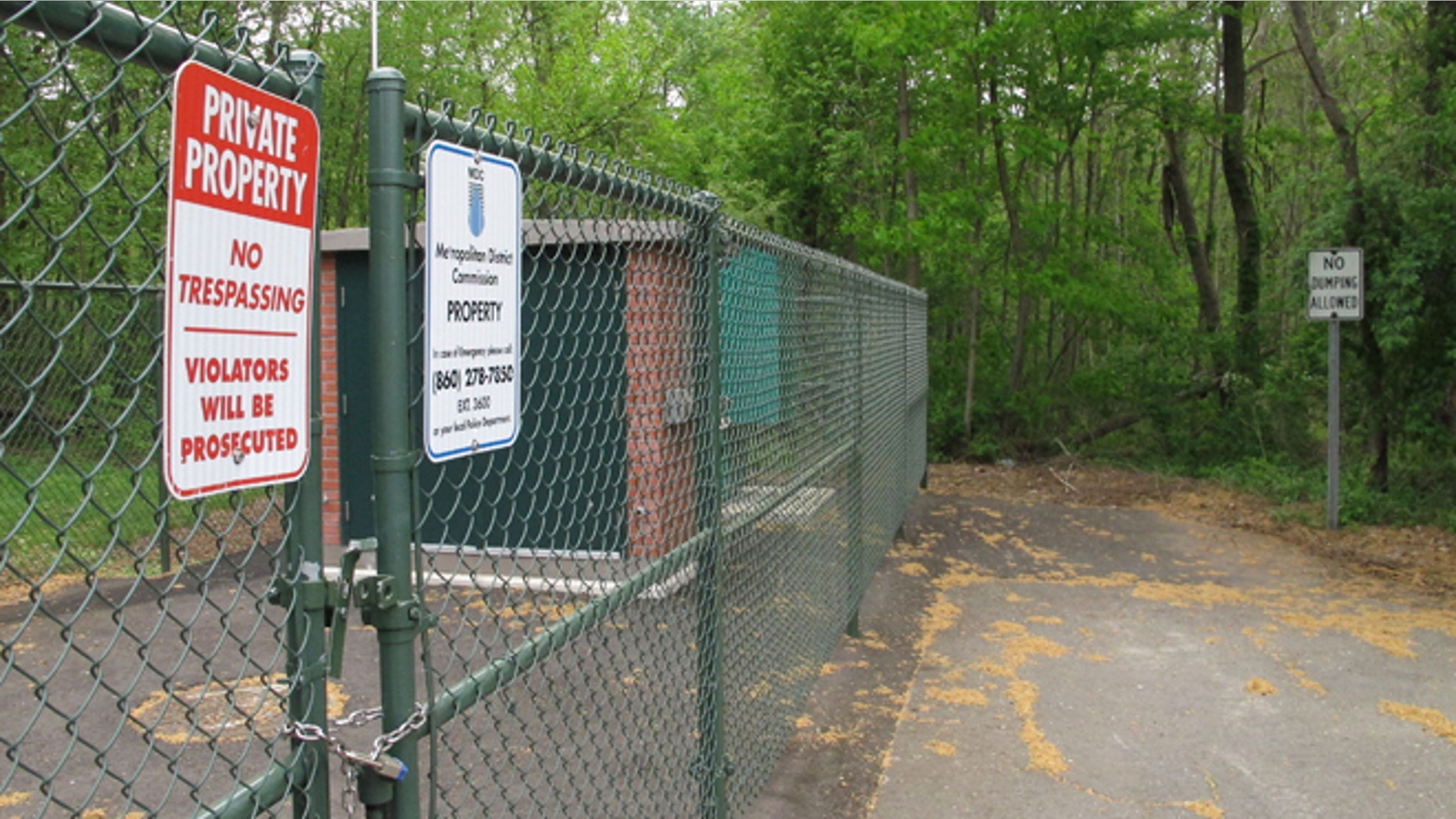 No trespassing and no dumping signs are posted in a neighborhood at the edge of a wooded area where the remains of seven people have been found since 2007 in Newington, Conn., Tuesday, May 12, 2015, Police believe a man serving prison time in Connecticut for manslaughter murdered all the victims, whose bodies were found in the woods just over the town line in New Britain, Conn. (AP Photo/Dave Collins)