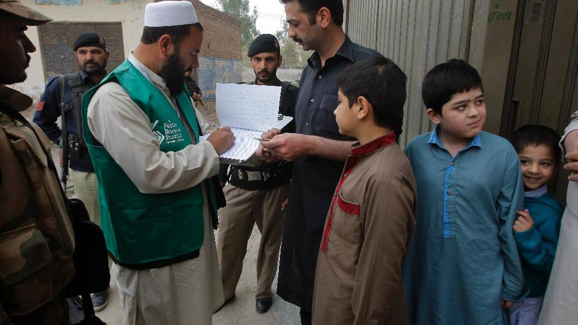 A government official collects data from a resident during a survey in Peshawar, Pakistan, Wednesday, March 15, 2017. Pakistan's chief census officer says the country has launched a national census for the first time in 19 years. Asif Bajwa says the census opened Wednesday and should be completed in two phases by May 15. (AP Photo/Muhammad Sajjad)