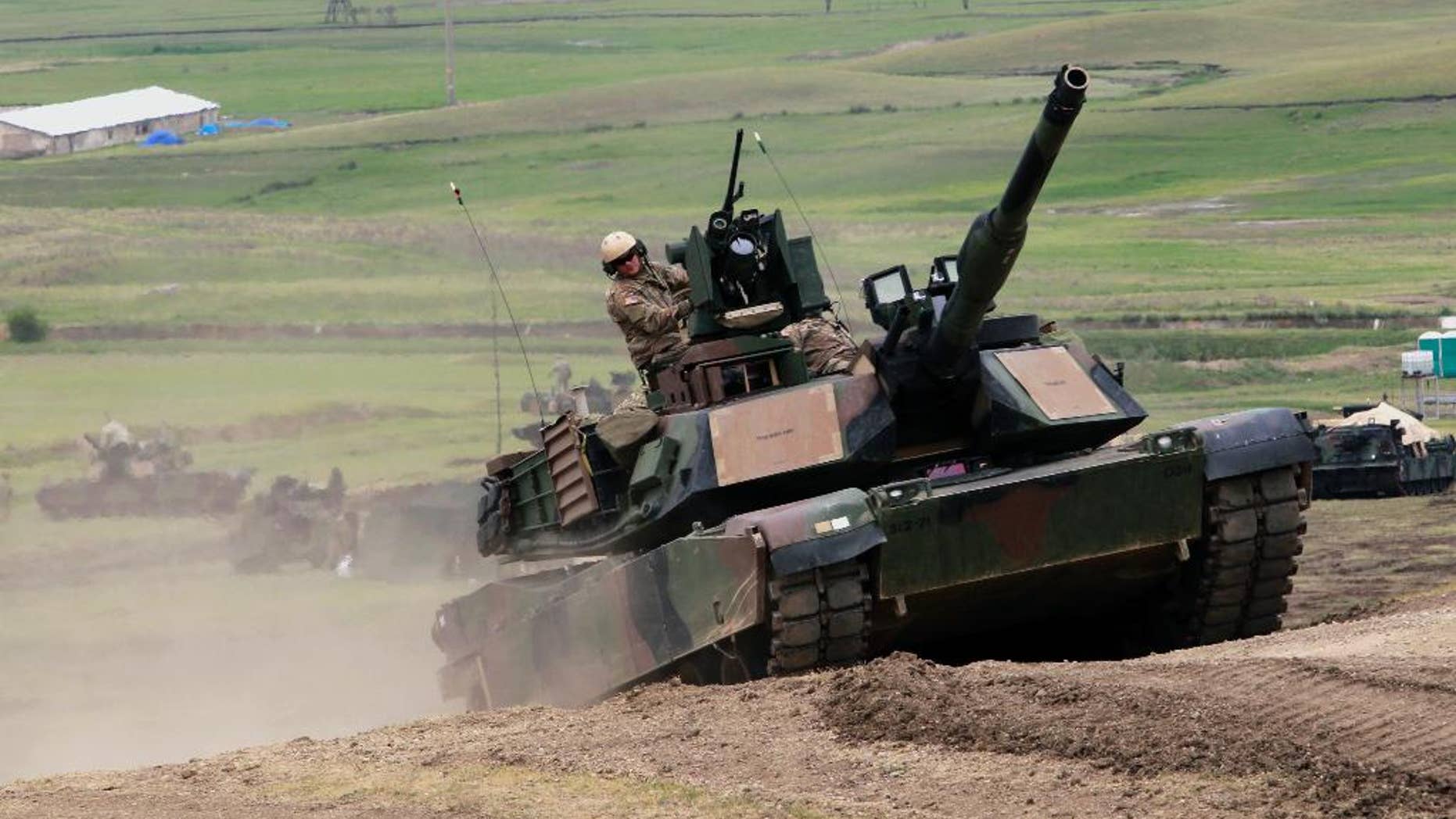U.S. M1A2 Abrams tank moves to firing positions during joint military exercises at the Vaziani military base outside Tbilisi, Georgia, Wednesday, May 18, 2016. About 1,300 U.S., British and Georgian troops conducted joint exercises aimed at training the former Soviet republic's military for participation in the NATO Response Force. (AP Photo/Shakh Aivazov)