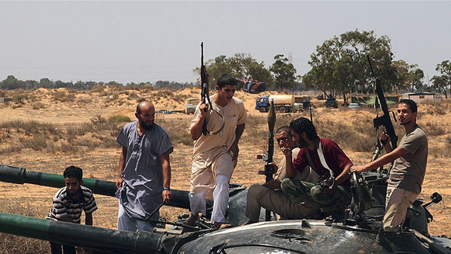 September 1: Freedom fighters climb on a tank for a lookout at a defensive outpost, some 30 kilometers outside Misrata, Libya.