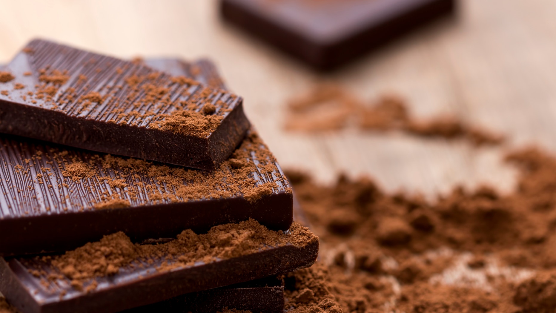 Dark Chocolate with Cocoa on Wooden Table