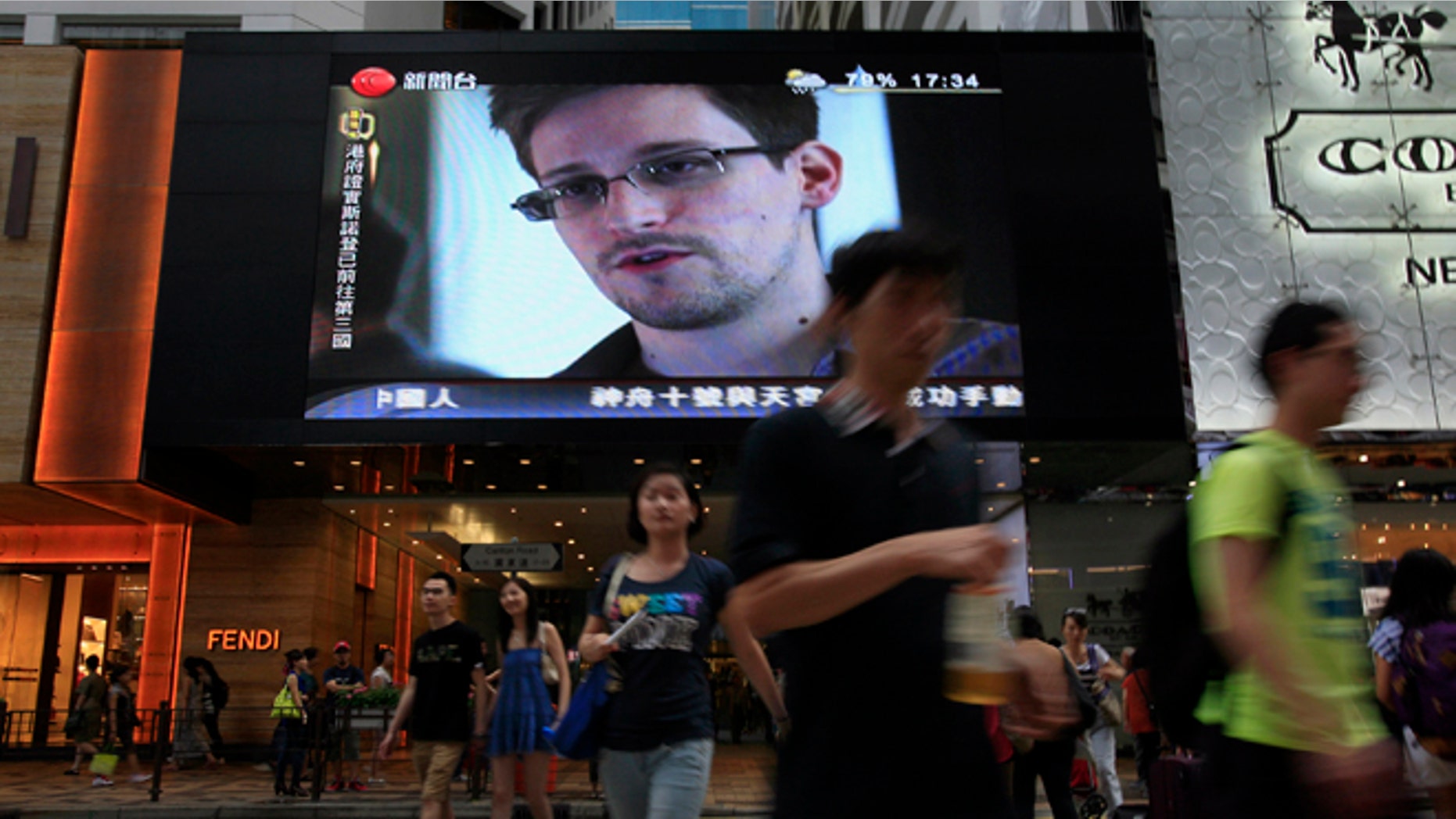 FILE - This June 23, 2013 file photo shows a TV screen shows a news report of Edward Snowden, a former CIA employee who leaked top-secret documents about sweeping U.S. surveillance programs, at a shopping mall in Hong Kong. The saga of Edward Snowden and the NSA makes one thing clear: The United States' central role in developing the Internet and hosting its most powerful players has made it the global leader in the surveillance game . Other countries, from dictatorships to democracies, are also avid snoopers, tapping into the high-capacity fiber optic cables to intercept Internet traffic, scooping their citizens' data off domestic servers, and even launching cyberattacks to win access to foreign networks. (AP Photo/Vincent Yu, File)