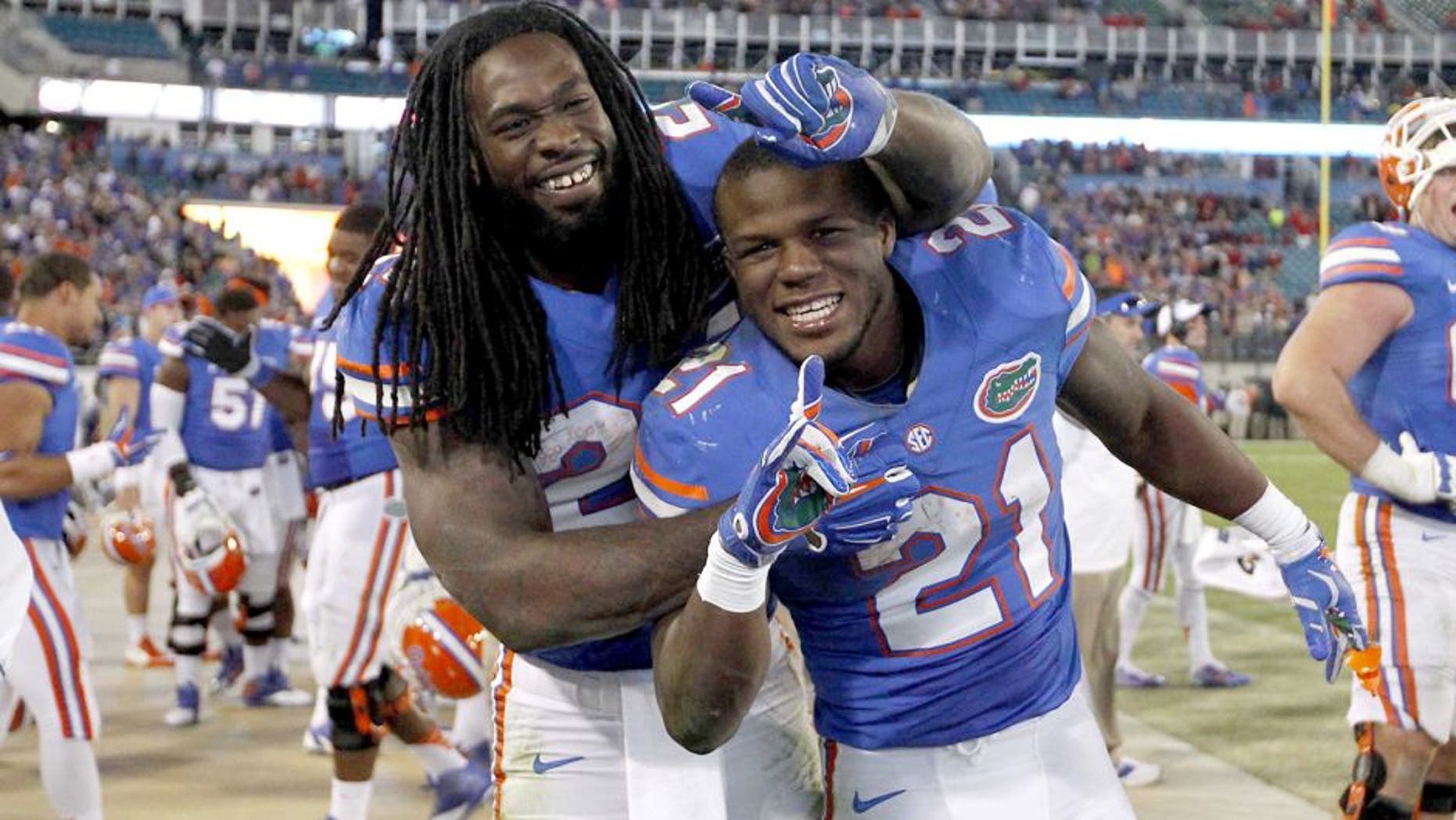 Nov 1, 2014; Jacksonville, FL, USA; Florida Gators running back Kelvin Taylor (21) and running back Matt Jones (24) celebrate during the fourth quarter against the Georgia Bulldogs at EverBank Field. Florida Gators defeated the Georgia Bulldogs 38-20. Mandatory Credit: Kim Klement-USA TODAY Sports