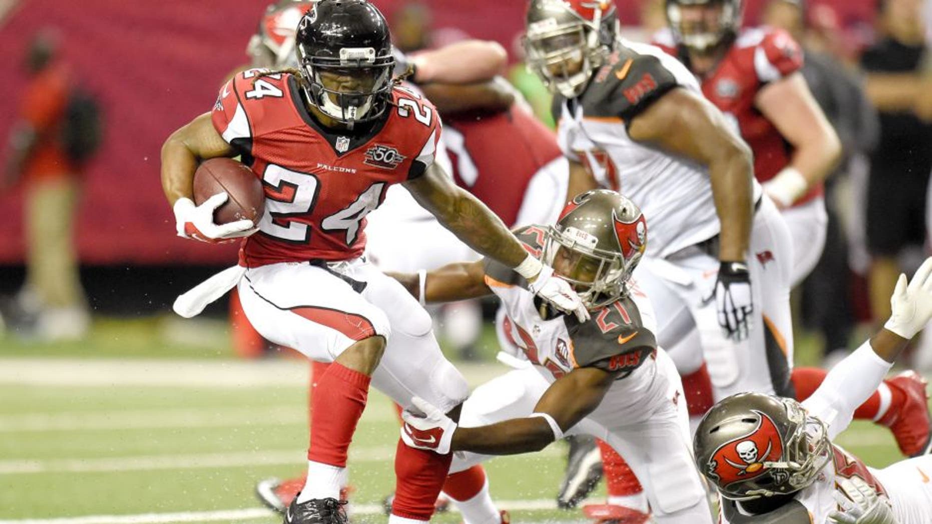 Nov 1, 2015; Atlanta, GA, USA; Atlanta Falcons running back Devonta Freeman (24) breaks a tackle by Tampa Bay Buccaneers cornerback Alterraun Verner (21) during the first half at the Georgia Dome. Mandatory Credit: Dale Zanine-USA TODAY Sports