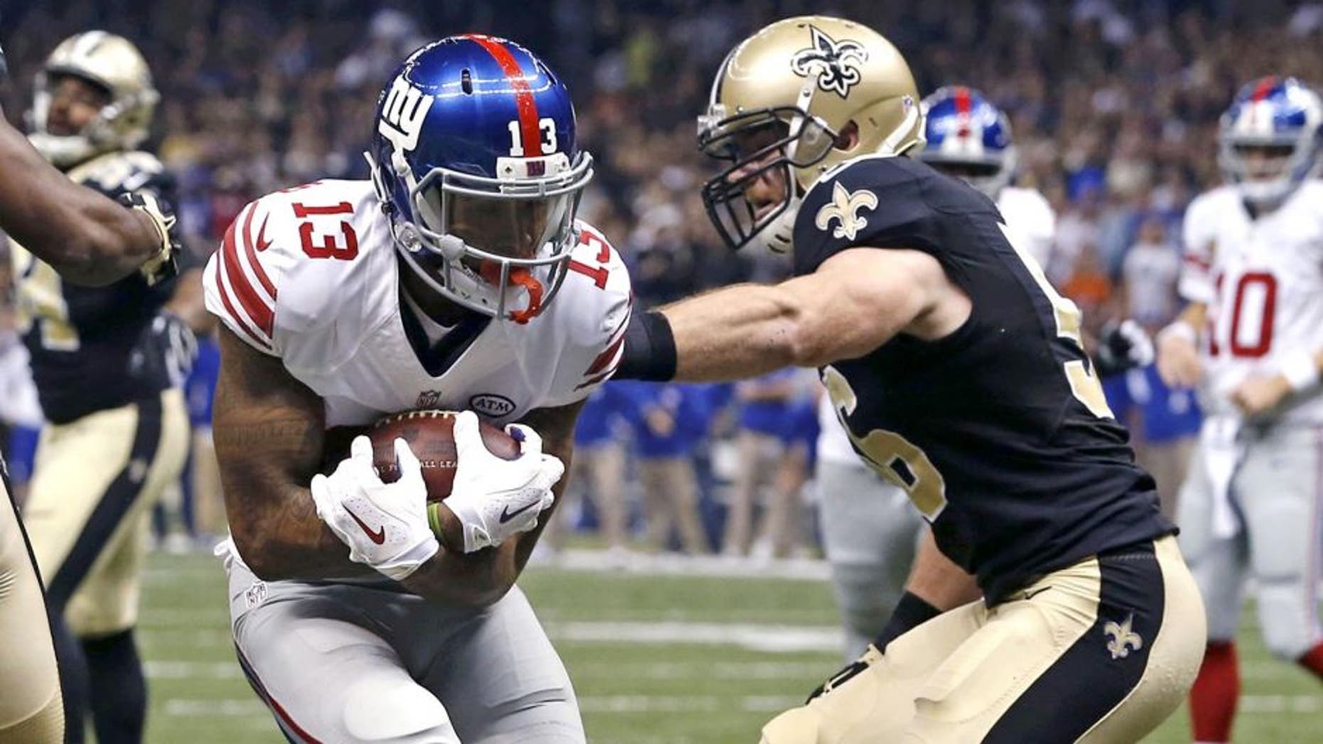New York Giants wide receiver Odell Beckham (13) pulls in a touchdown reception in front of New Orleans Saints cornerback Delvin Breaux (40) in the first half of an NFL football game in New Orleans, Sunday, Nov. 1, 2015. (AP Photo/Jonathan Bachman)