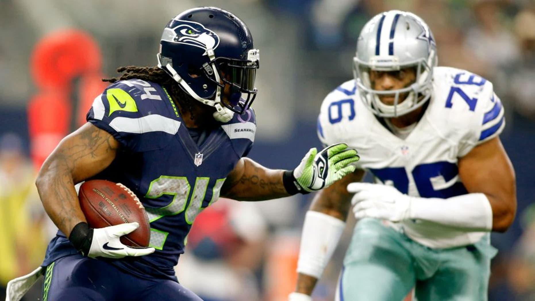 Nov 1, 2015; Arlington, TX, USA; Seattle Seahawks running back Marshawn Lynch (24) runs the ball against Dallas Cowboys defensive end Greg Hardy (76) in the second quarter at AT&T Stadium. Mandatory Credit: Tim Heitman-USA TODAY Sports