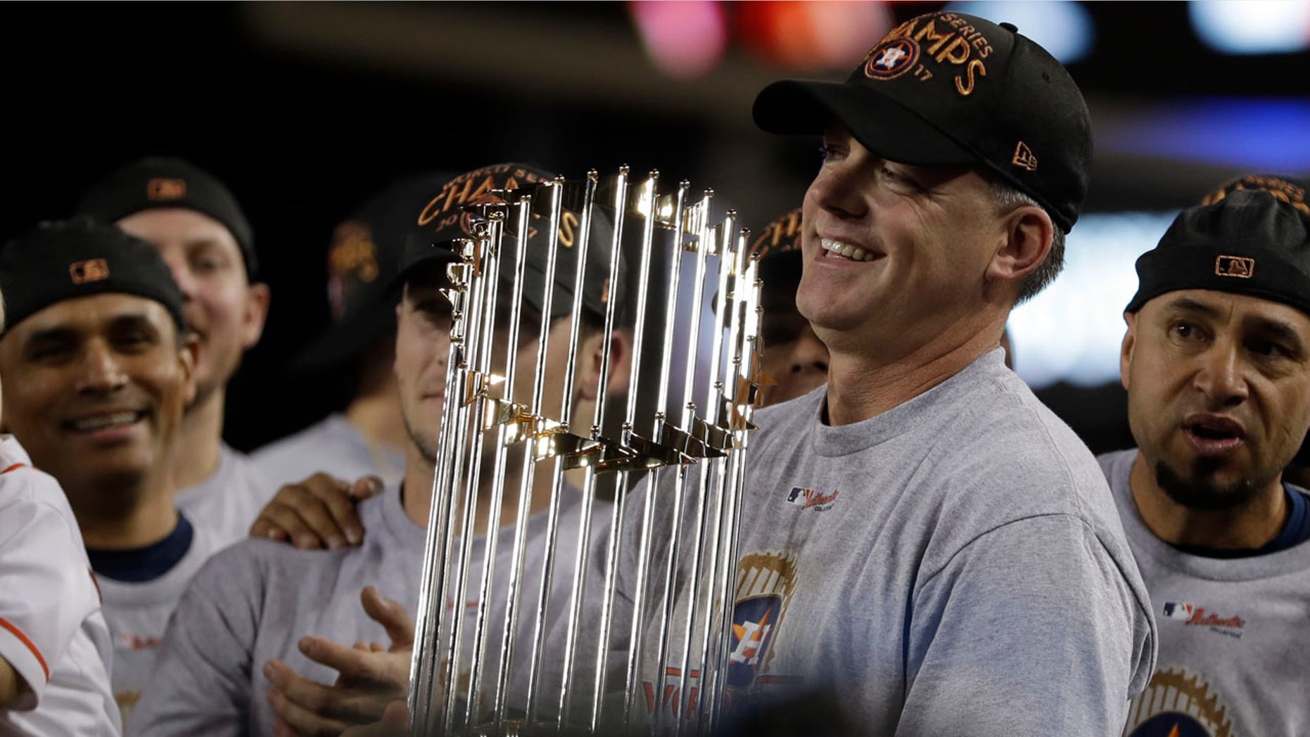 Houston Astros manager A.J. Hinch holds the championship trophy after Game 7 of baseball's World Series against the Dodgers in Los Angeles, Nov. 1, 2017.