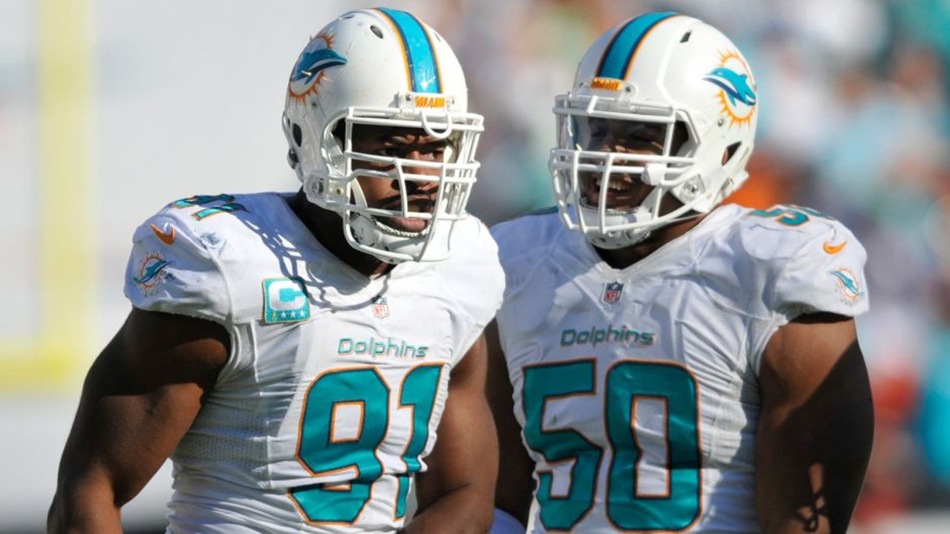 Nov 2, 2014; Miami Gardens, FL, USA; Miami Dolphins defensive tackle Earl Mitchell (90) celebrates with Miami Dolphins defensive end Olivier Vernon (50) after a sack against the San Diego Chargers at Sun Life Stadium. Miami defeated the Chargers 37-0. Mandatory Credit: Brad Barr-USA TODAY Sports