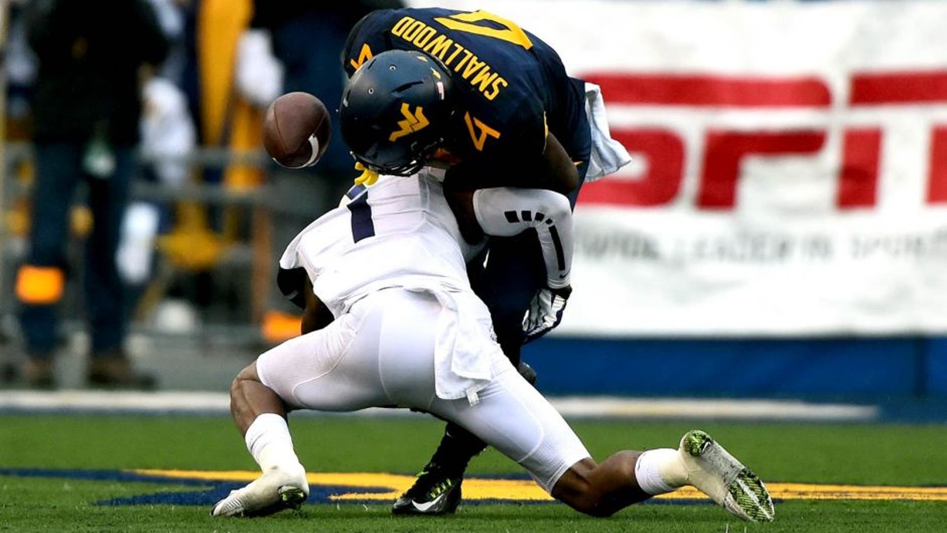 Nov 1, 2014; Morgantown, WV, USA; TCU Horned Frogs safety Chris Hackett (1) forces West Virginia Mountaineers running back Wendell Smallwood (4) to fumble during the second quarter at Milan Puskar Stadium. Mandatory Credit: Tommy Gilligan-USA TODAY Sports