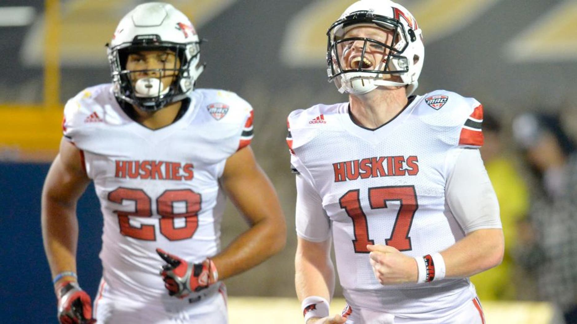 Northern Illinois quarterback Ryan Graham (17) and running back Joel Bouagnon (28) celebrate after Bouagnon's 2-yard rushing touchdown during the fourth quarter of an NCAA college football game against Toledo on Tuesday, Nov. 3, 2015, in Toledo, Ohio. Northern Illinois won 32-27. (AP Photo/David Richard)