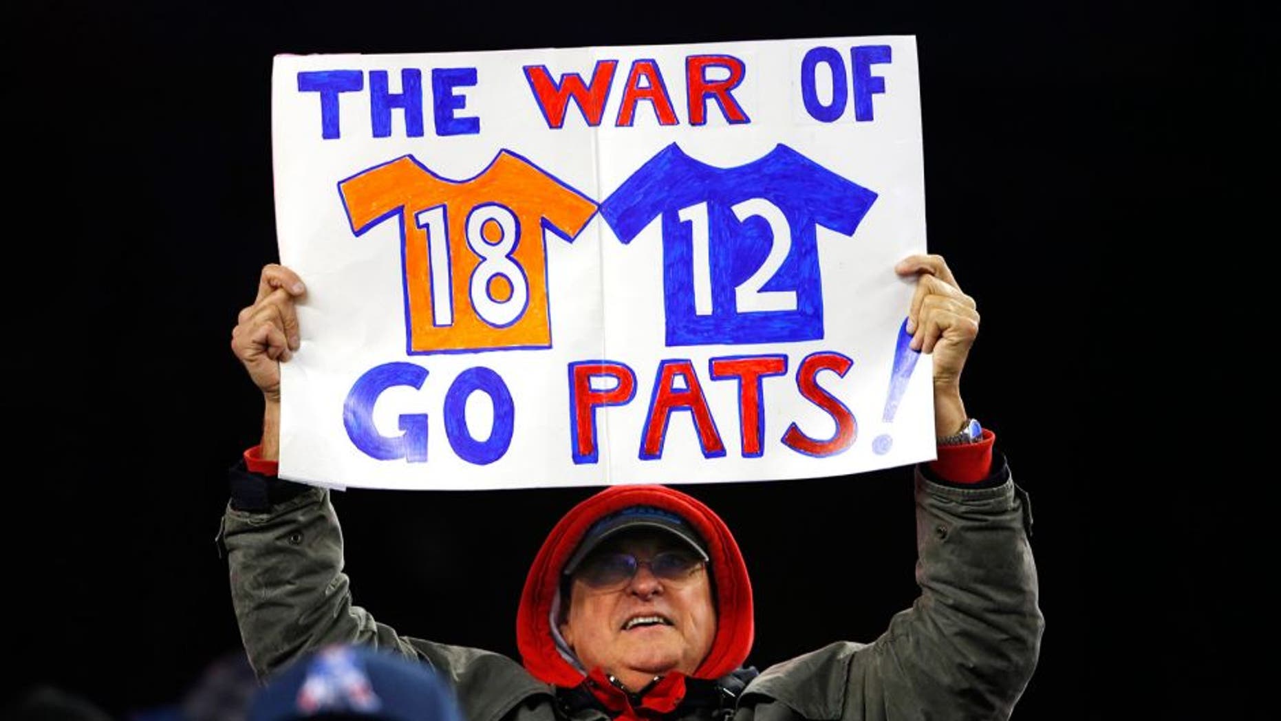 Nov 2, 2014; Foxborough, MA, USA; A fan holds up a sign about New England Patriots quarterback Tom Brady and Denver Broncos quarterback Peyton Manning during the fourth quarter of New England's 43-21 win at Gillette Stadium. Mandatory Credit: Winslow Townson-USA TODAY Sports