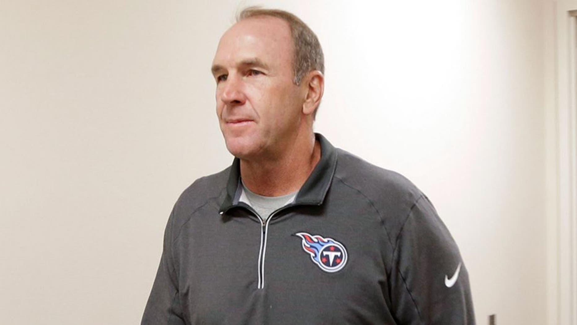 The Tennessee Titans assistant head coach/tight ends coach Mike Mularkey, left, walks to a news conference after it was announced that he has been named the interim head coach after the team fired head coach Ken Whisenhunt Tuesday, Nov. 3, 2015, in Nashville, Tenn. (AP Photo/Mark Humphrey)