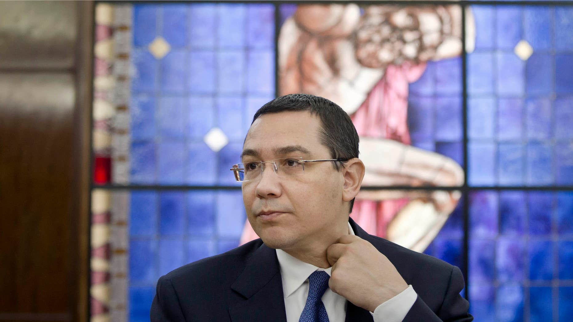June 9, 2015: Romanian Prime Minister, Victor Ponta, adjusts his collar during a meeting with foreign media at the government headquarters in Bucharest.
