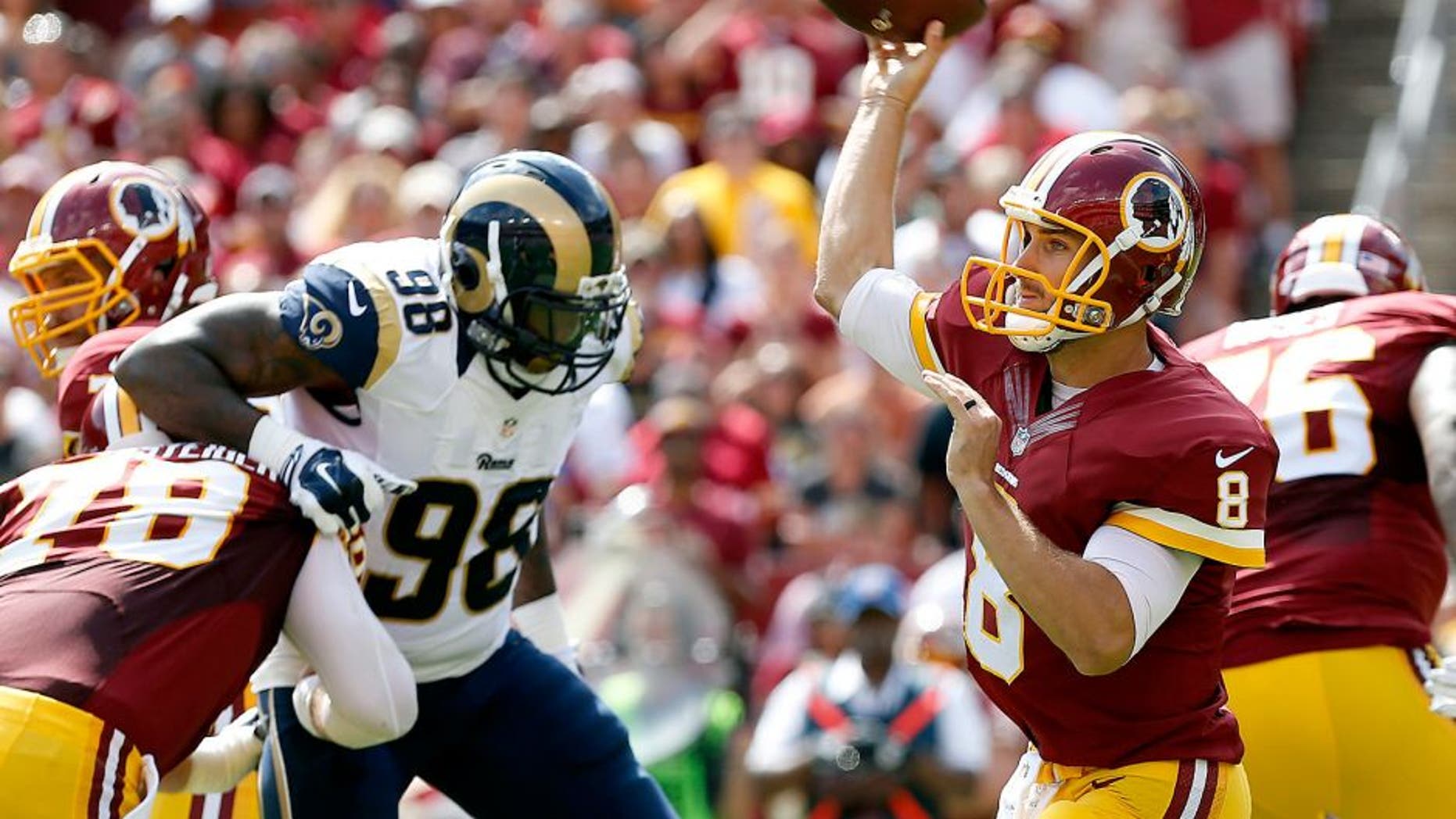 Sep 20, 2015; Landover, MD, USA; Washington Redskins quarterback Kirk Cousins (8) throws the ball as St. Louis Rams defensive tackle Nick Fairley (98) chases in the first quarter at FedEx Field. Mandatory Credit: Geoff Burke-USA TODAY Sports