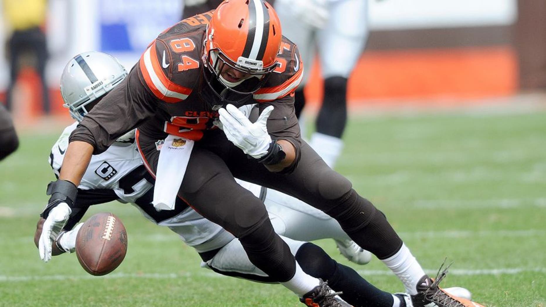 Sep 27, 2015; Cleveland, OH, USA; Cleveland Browns tight end Rob Housler (84) has a the ball stripped by Oakland Raiders free safety Charles Woodson (24) during the first half at FirstEnergy Stadium. Mandatory Credit: Ken Blaze-USA TODAY Sports
