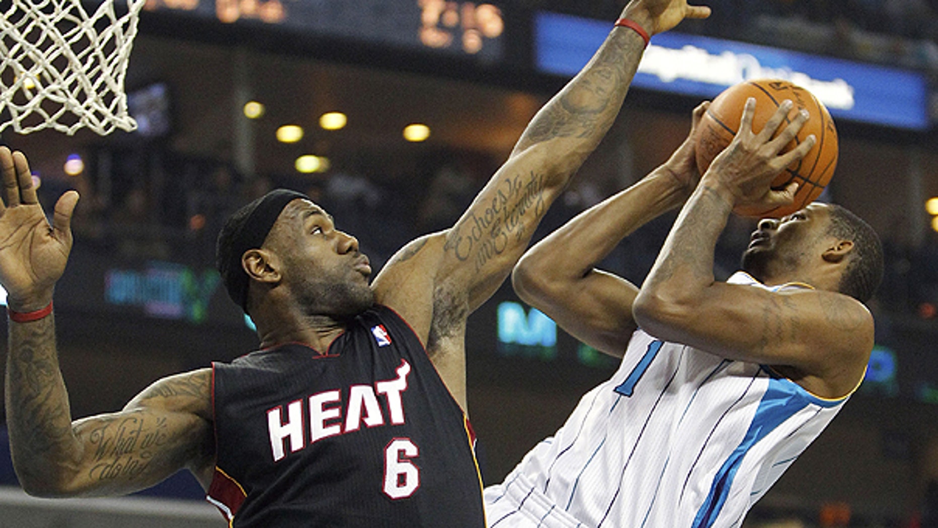 NOv. 5: Miami Heat forward LeBron James (6) contests the shot of New Orleans Hornets small forward Trevor Ariza (1) in the first half of an NBA basketball game in New Orleans.