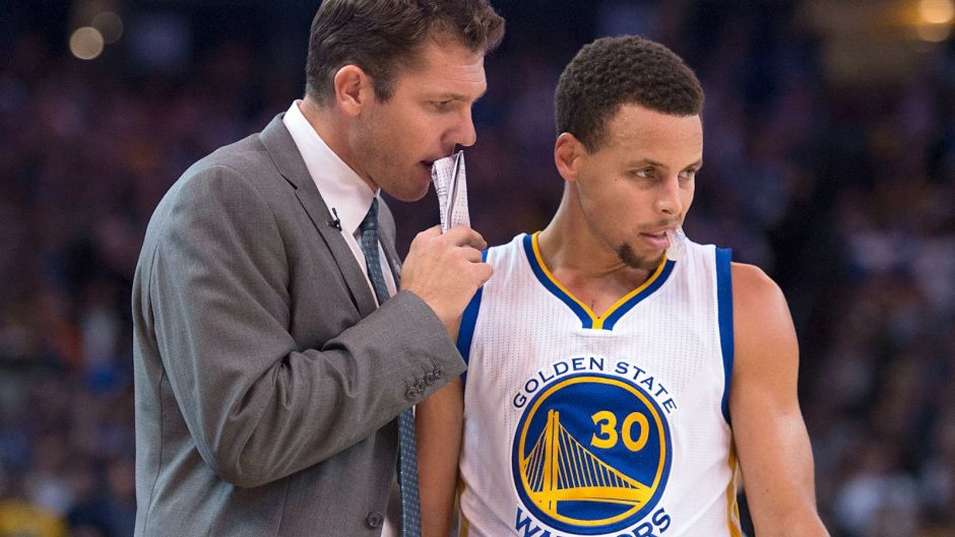 November 4, 2015; Oakland, CA, USA; Golden State Warriors interim head coach Luke Walton (left) talks to guard Stephen Curry (30) during the fourth quarter against the Los Angeles Clippers at Oracle Arena. The Warriors defeated the Clippers 112-108. Mandatory Credit: Kyle Terada-USA TODAY Sports