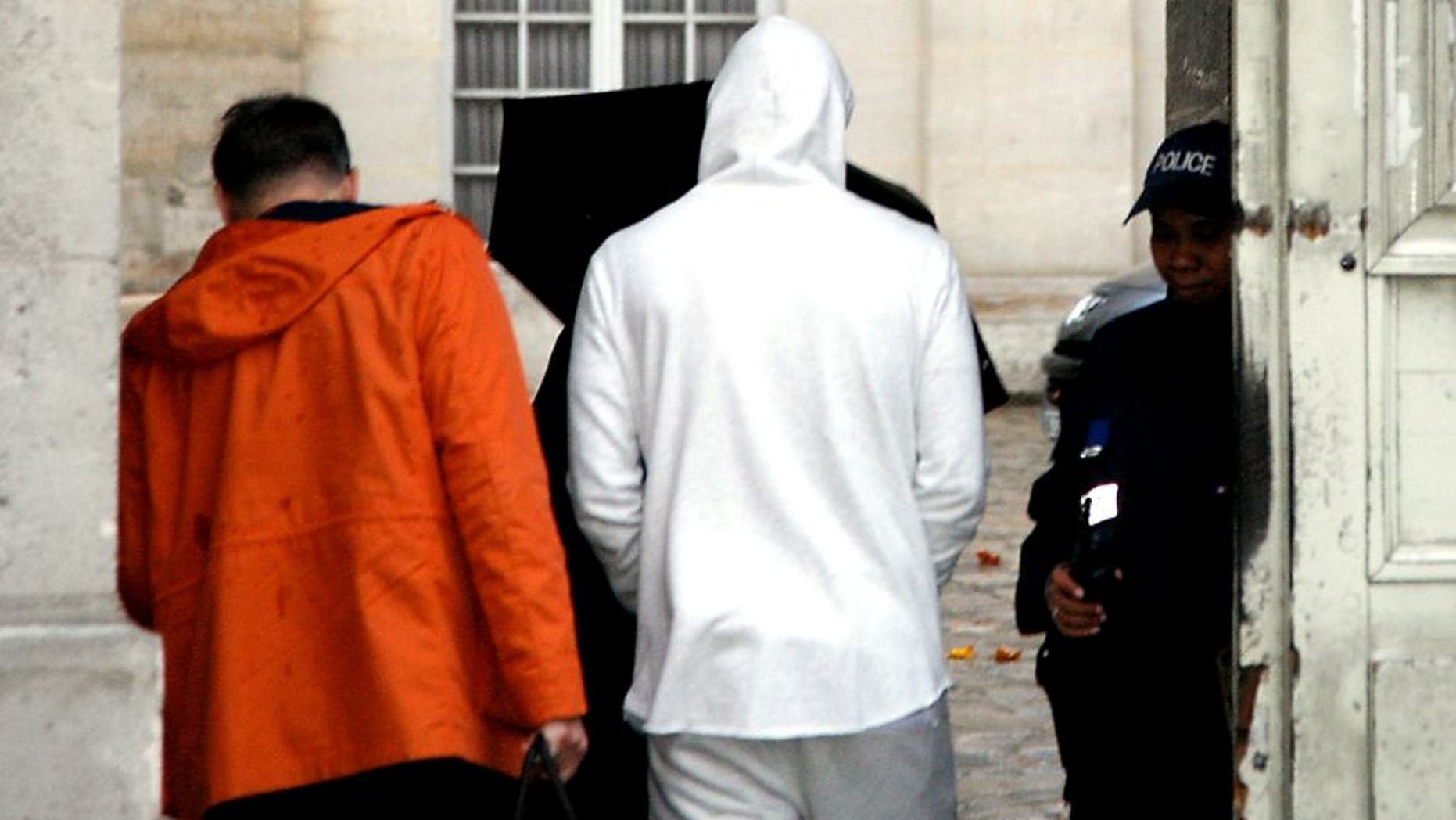 French footballer Karim Benzema (C), wearing a white hooded jersey, arrives at the police station in Versailles, southwest of Paris, on November 4, 2015. French footballer Karim Benzema was arrested on November 4 in connection with blackmail over a sextape featuring fellow player Mathieu Valbuena, a source close to the probe told AFP. AFP PHOTO / MATTHIEU ALEXANDRE (Photo credit should read MATTHIEU ALEXANDRE/AFP/Getty Images)