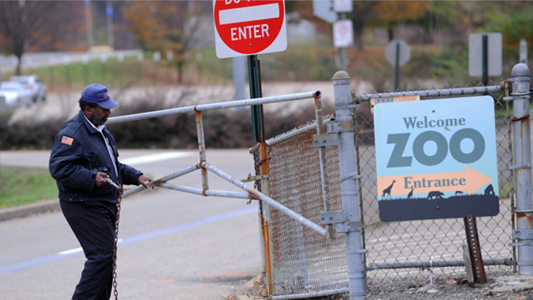 Nov. 4, 2012: A security guard closes the gate at the Pittsburgh Zoo, where zoo officials say a young boy was killed after he fell into the exhibit that was home to a pack of African painted dogs.