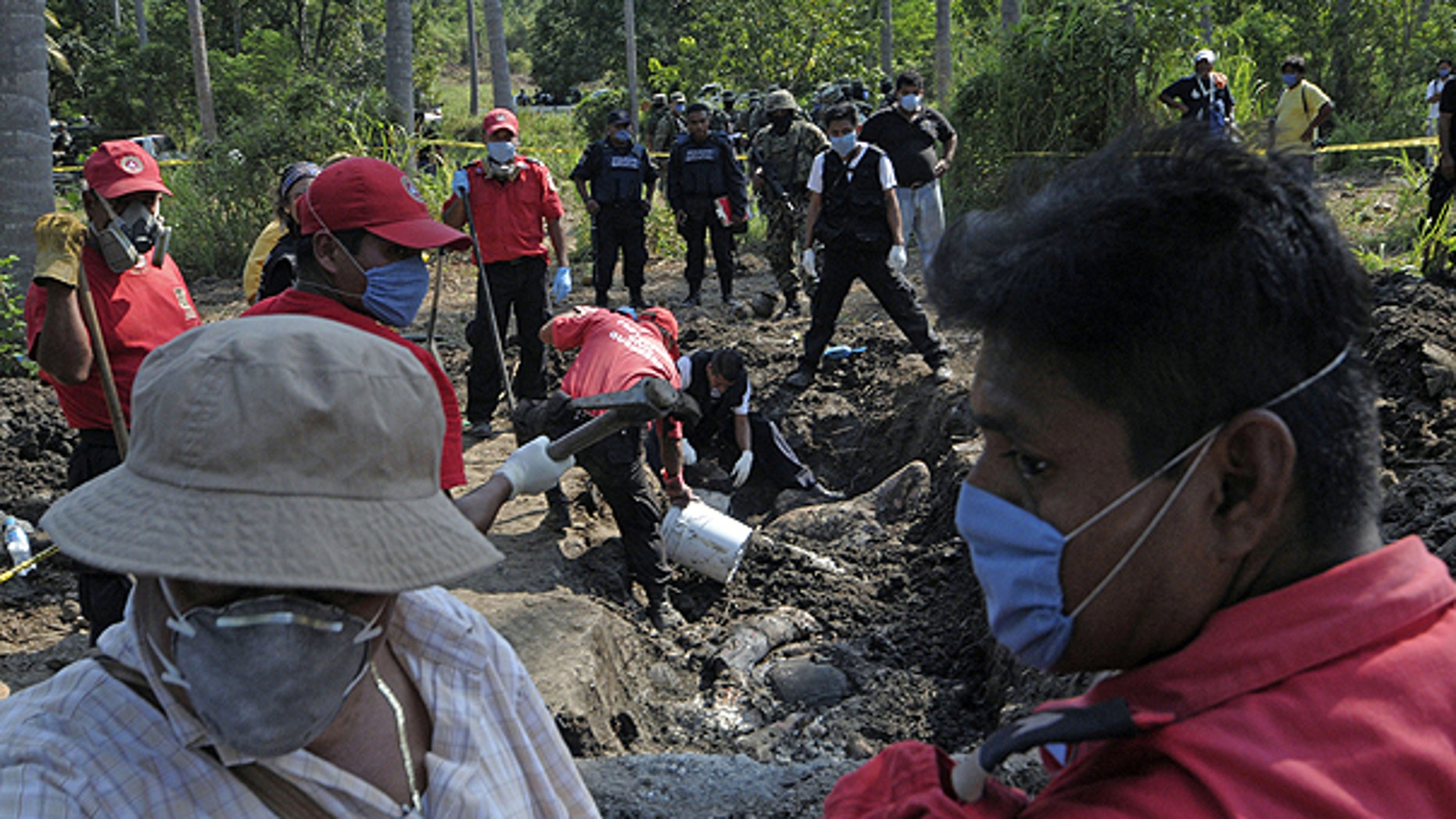 Nov. 3: Civil protection and forensic workers recover a body which was buried at a field in the town of Tuncingo, southern Mexico.