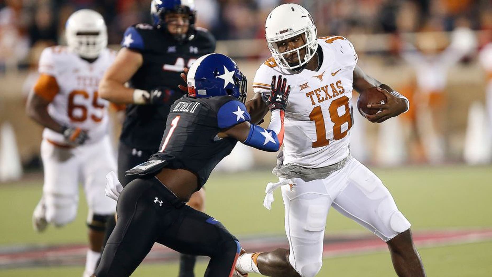 Texas' Tyrone Swoopes runs against Texas Tech's Nigel Bethel II during an NCAA college football game in Lubbock, Texas, Saturday, Nov. 1, 2014. (AP Photo/Lubbock Avalanche-Journal, Tori Eichberger)